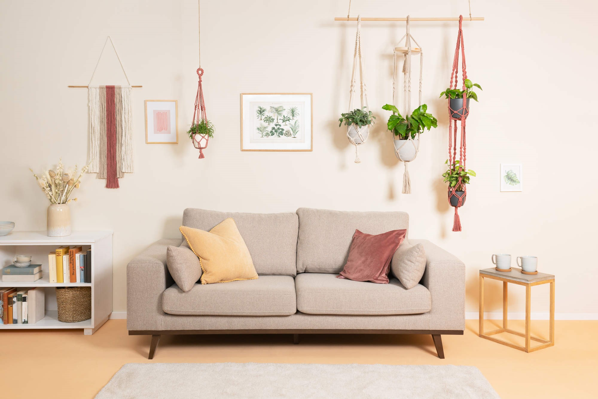 Pohovka, koberec a kvetinová dekorácia v miestnosti so stenou v príjemnom prírodnom tóne.