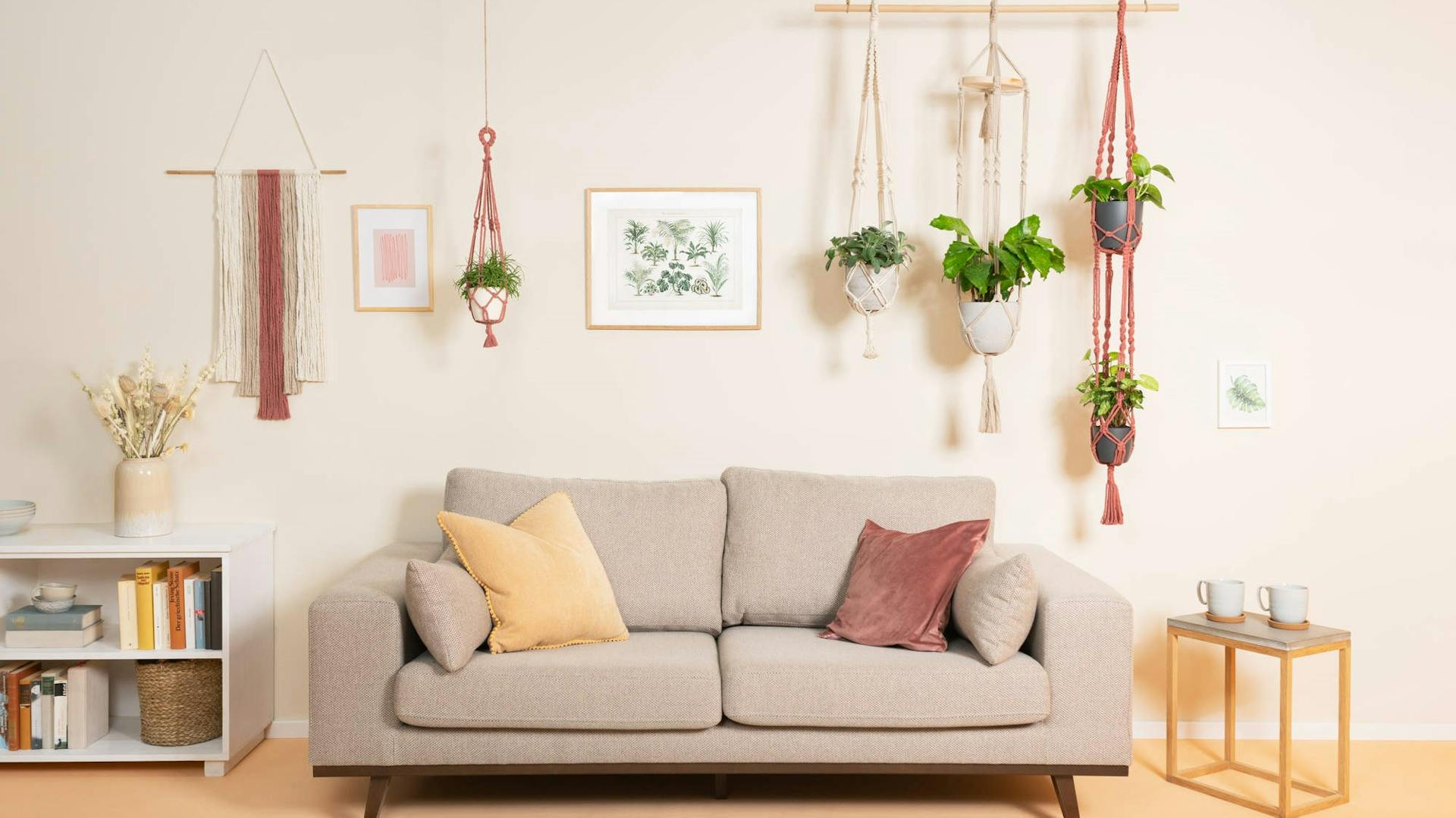 Sofa, Teppich und Blumendeko in Raum mit Wand in gemütlichem Naturton.