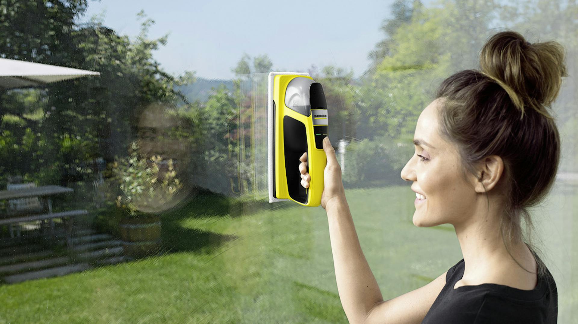 Frau putzt Fensterscheibe mit Akkuwischer von Kärcher