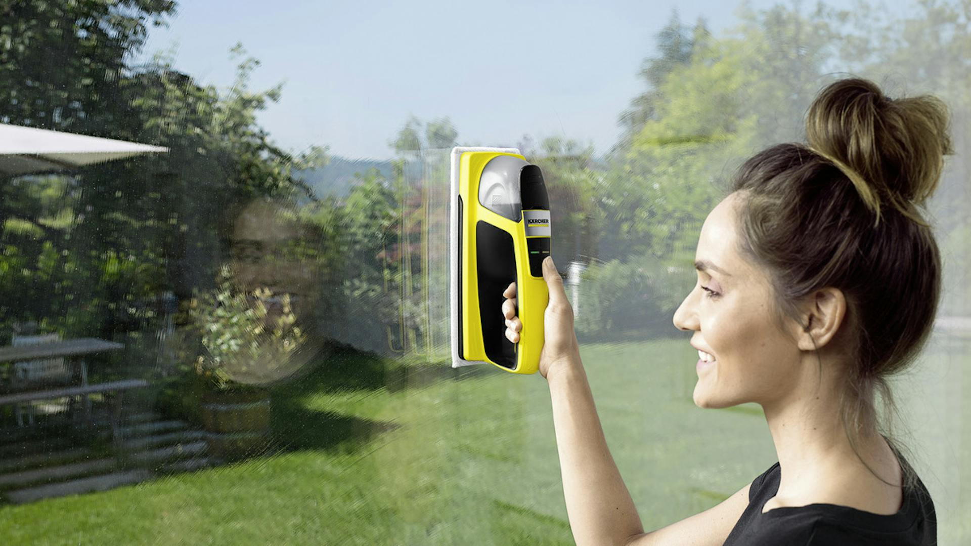Frau putzt Fensterscheibe mit Akkuwischer von Kärcher