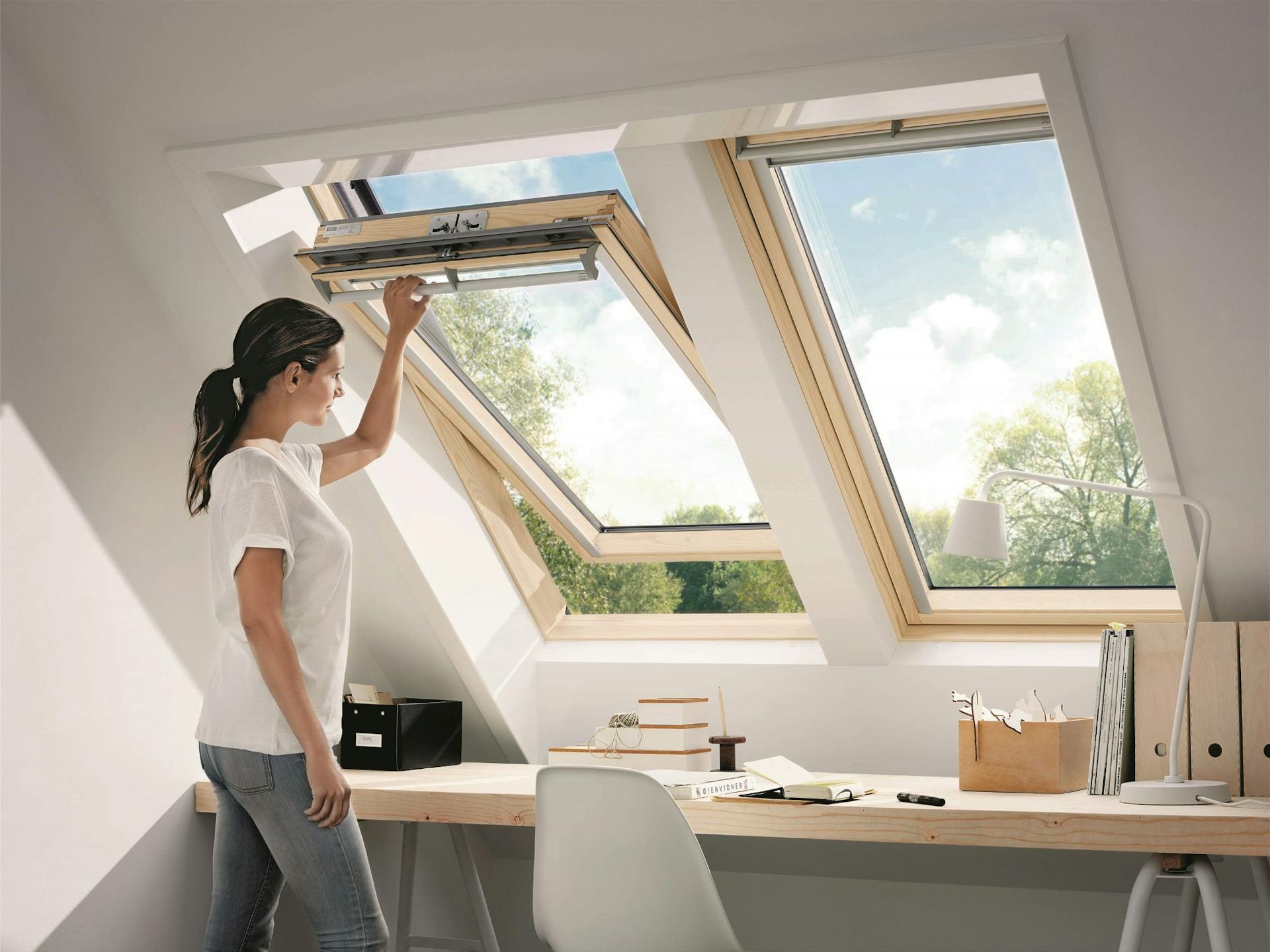 Donna apre una finestra pulita su tetto inclinato.