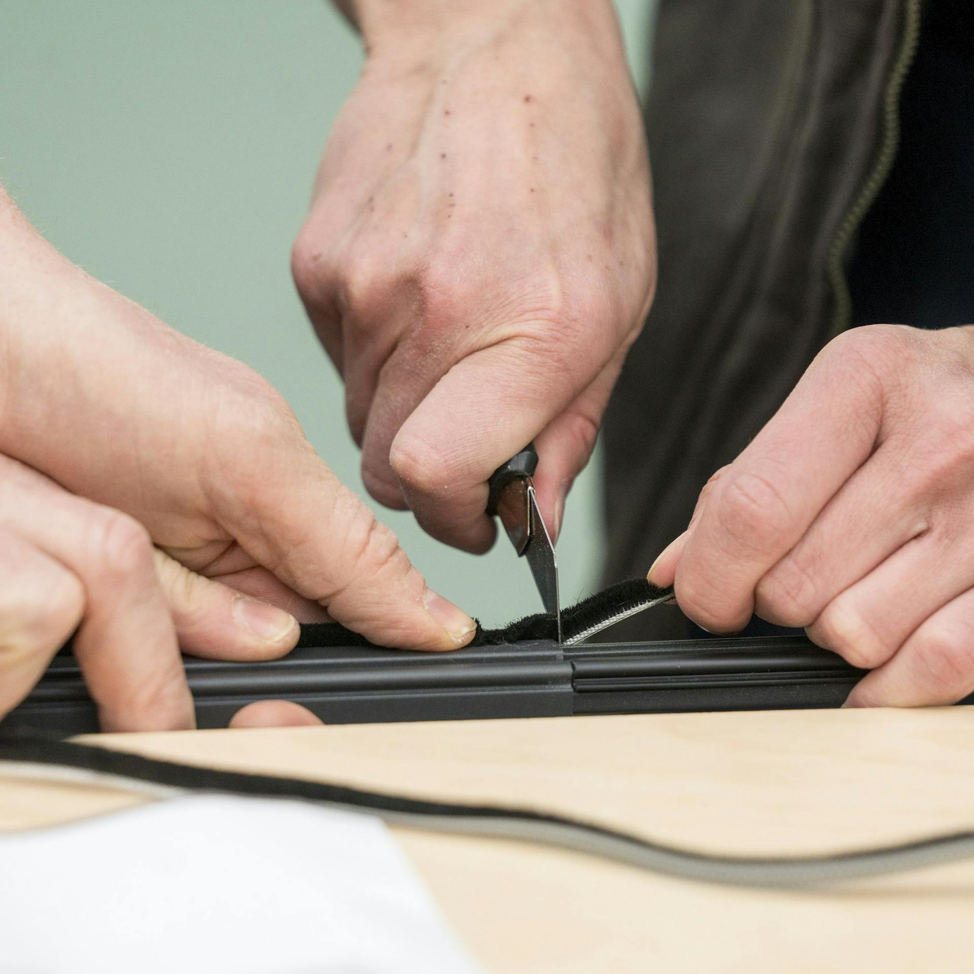 Handwerker schneiden die Bürstendichtung zu.