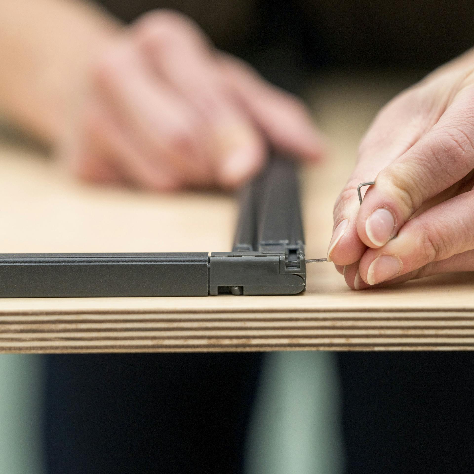 Handwerkerin bringt Haltewinkel an.