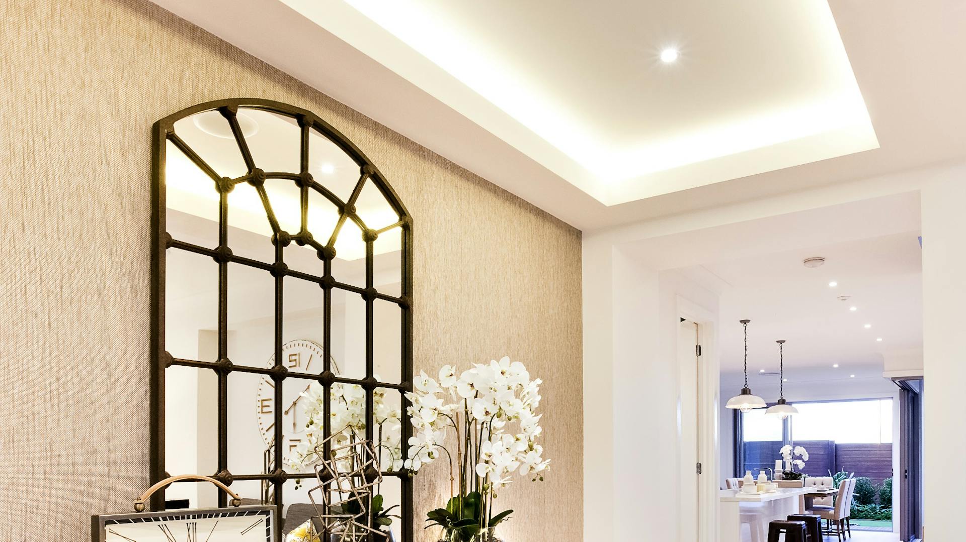 Hausflur mit indirekter Beleuchtung und kleinem Tisch mit Uhr und Spiegel