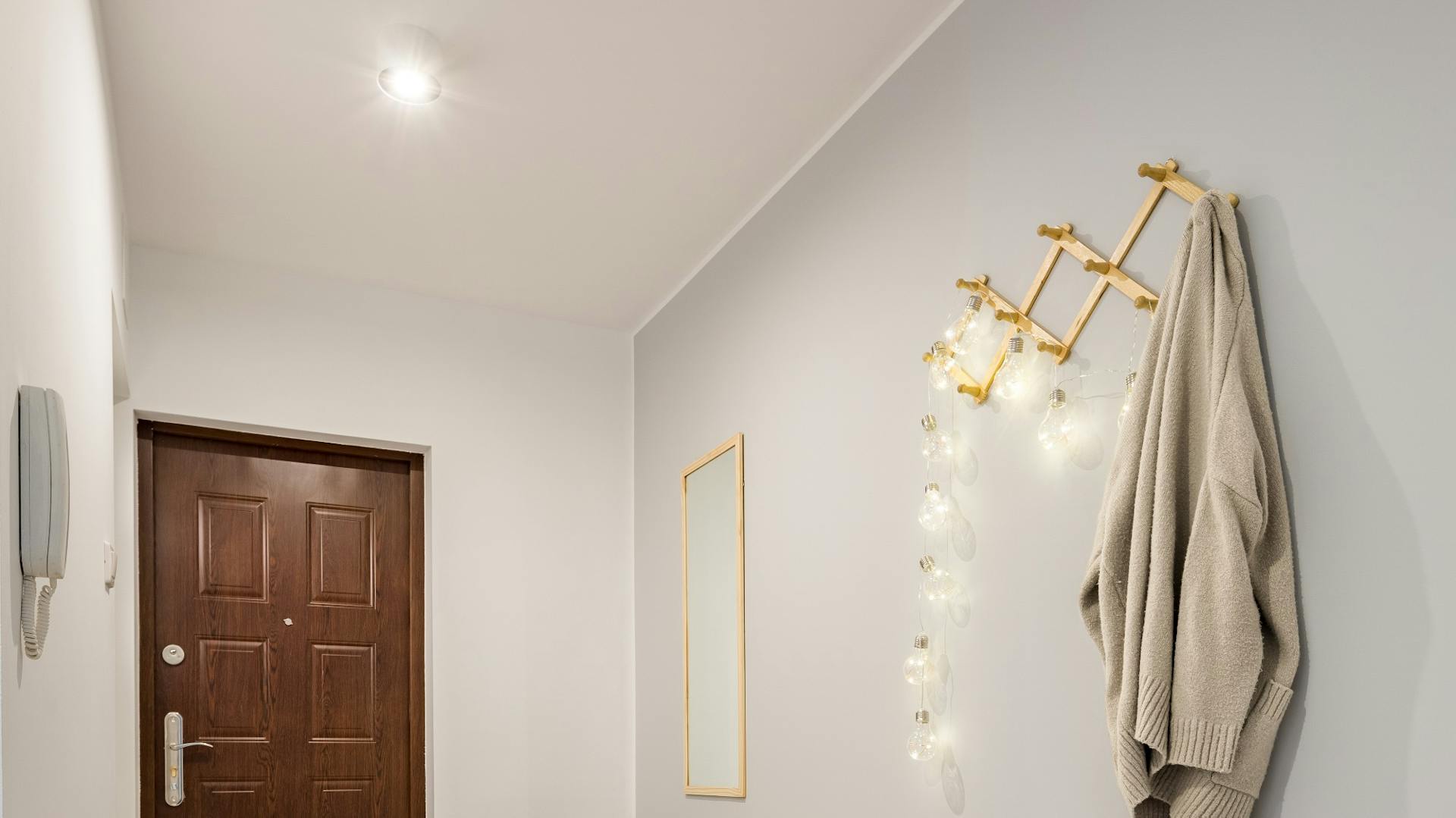 Eingangsflur einer Wohnung mit Deckenleuchte, Lichterkette und Garderobe