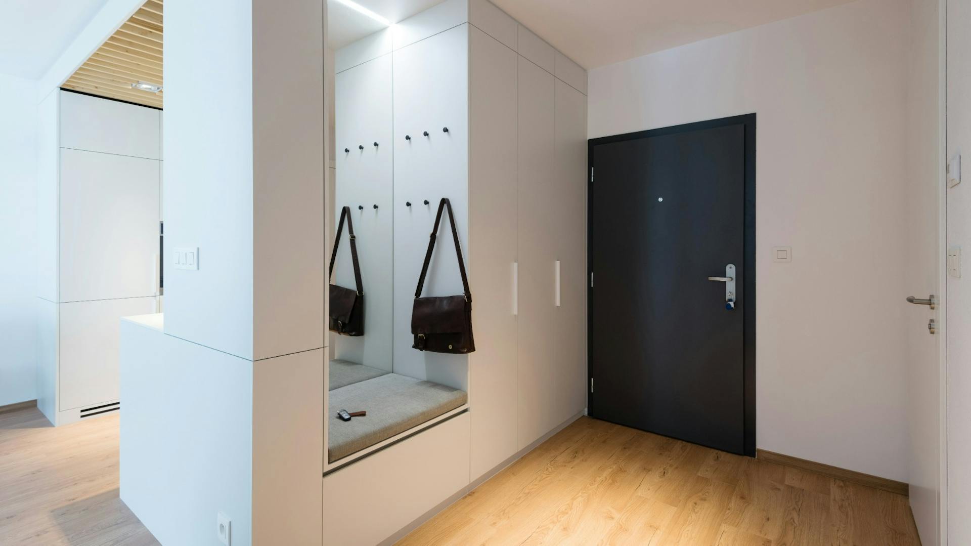 Wohnungsflur mit Garderobennische mit Spiegel, Sitzbank und indirekter Beleuchtung