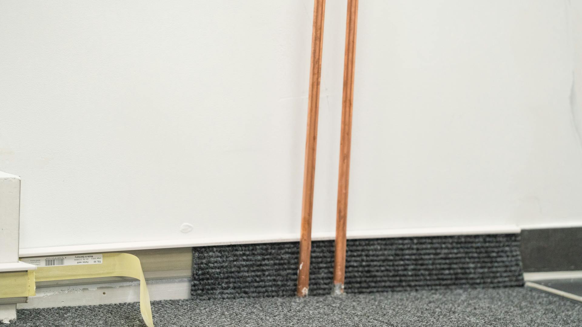 Teppichbelag, der auf einer Sockelleiste angebracht wird.