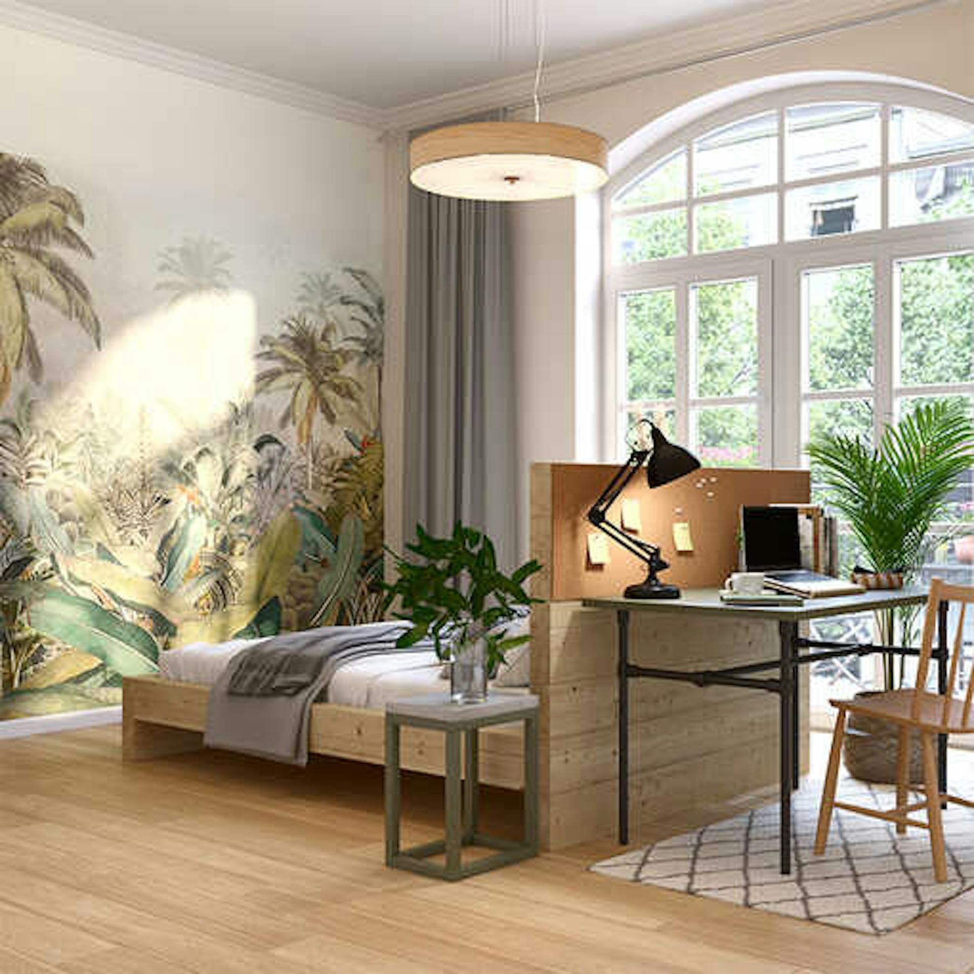 Bett Franz mit einem erhöhtem Kopfteil, an dem Tisch Robert drangestellt worden ist, steht mittig im Raum , der eine einzelne Wand mit Dschungeltapete besitzt.