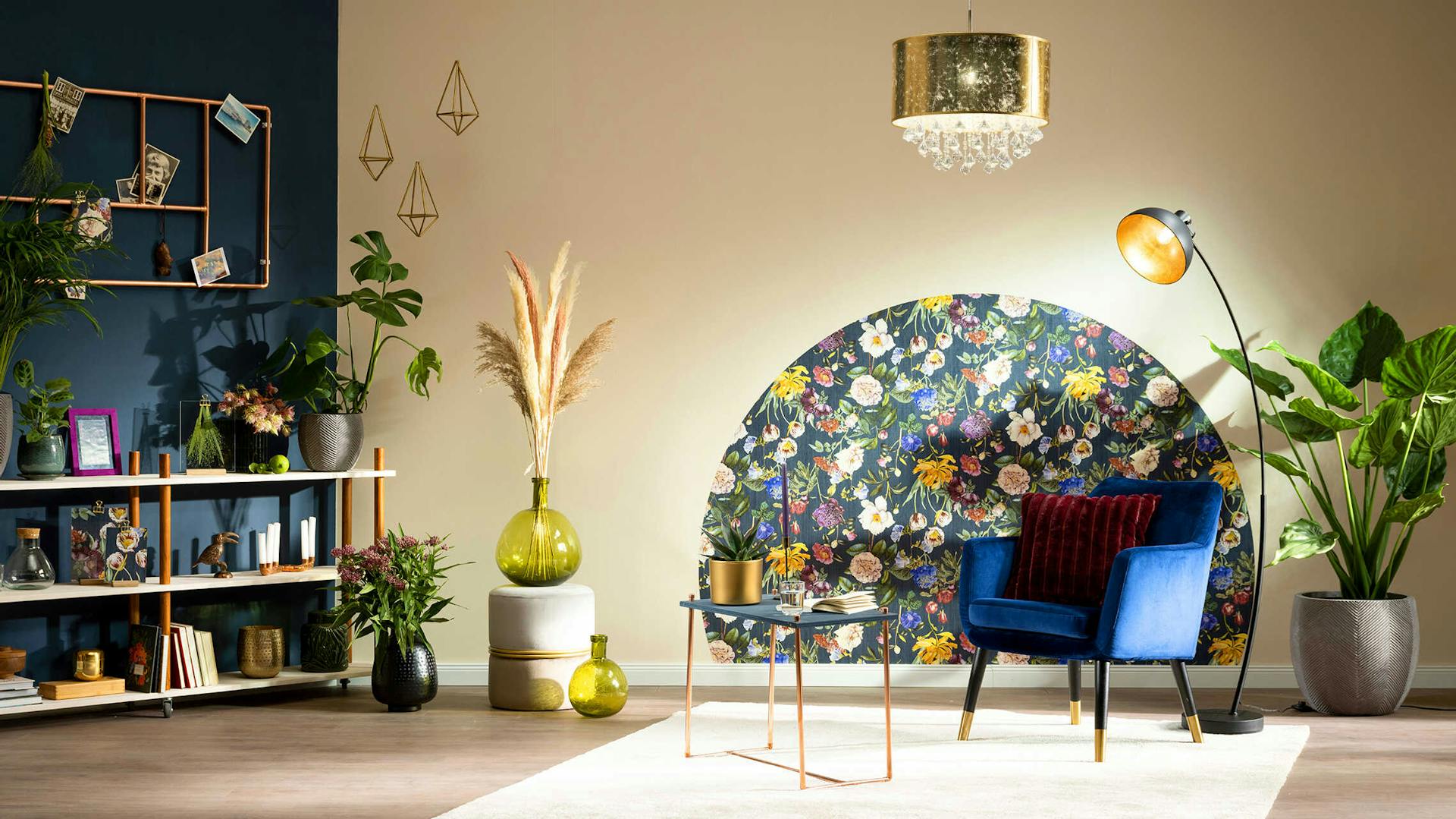 Ein zweifarbiger Raum, in dem in der Mitte ein lila Sessel und ein Beistelltisch aus Kupferrohr steht, wo an der Wand hinter ihnen eine halbrunde Tapete mit Blumenmotiv angebracht worden ist.