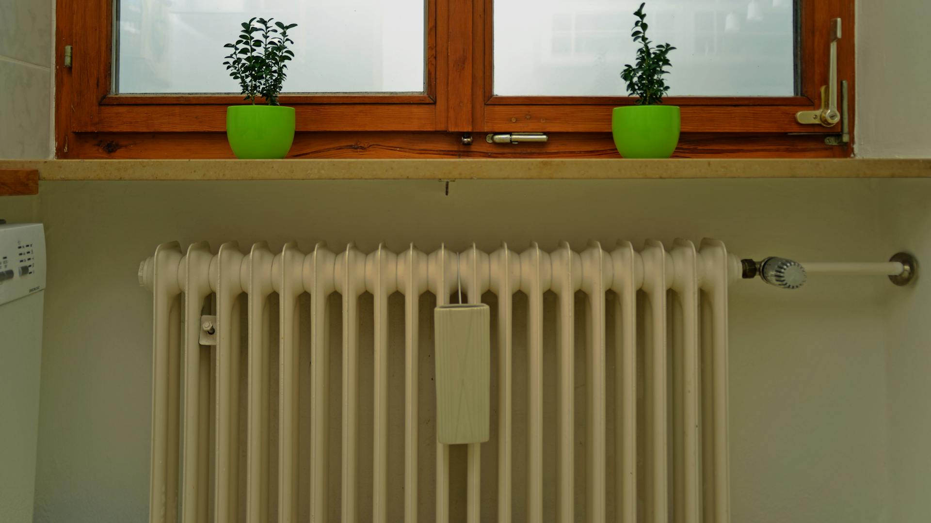 Ein Heizkörper ist an einer Wand unter einem Fenster angebracht.