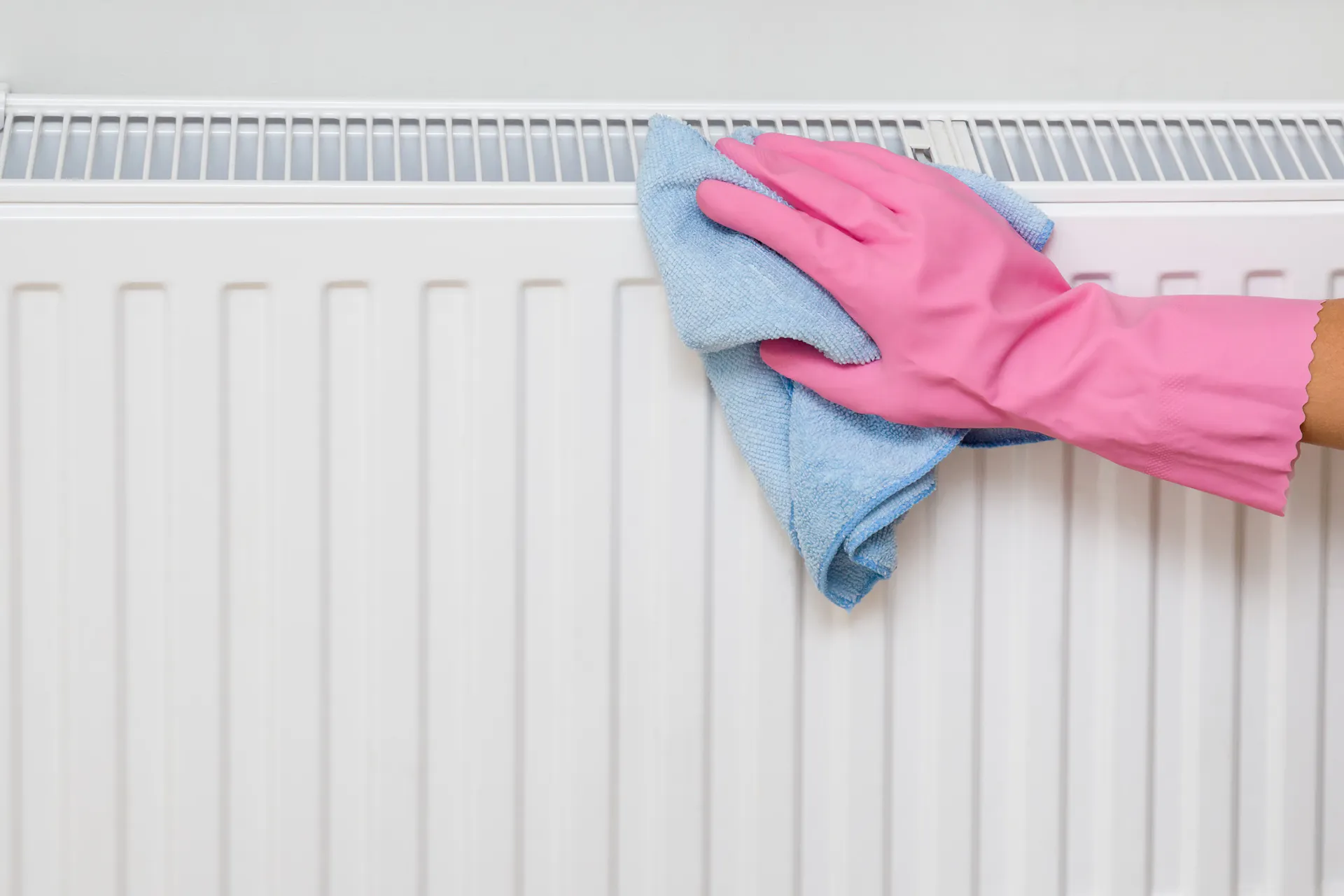 Un radiateur est nettoyé de l'extérieur avec un chiffon de nettoyage.