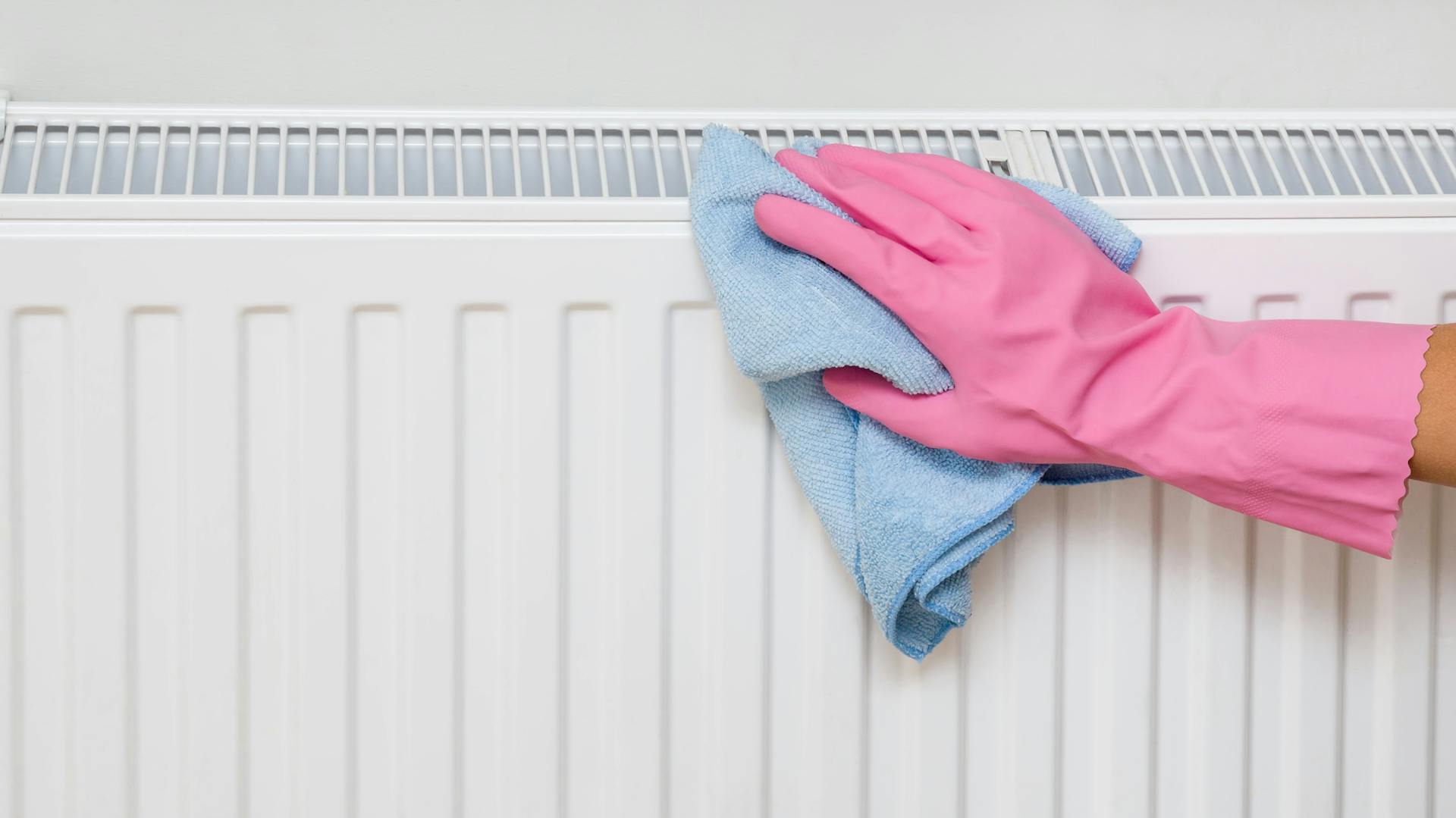 Un radiatore viene pulito dall’esterno con un panno per la pulizia.