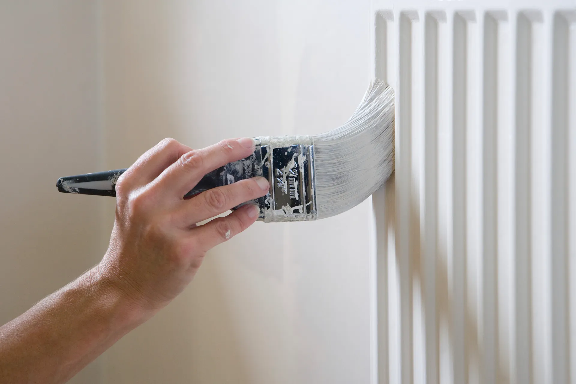 Un radiateur est peint avec de la laque blanche pour radiateur.