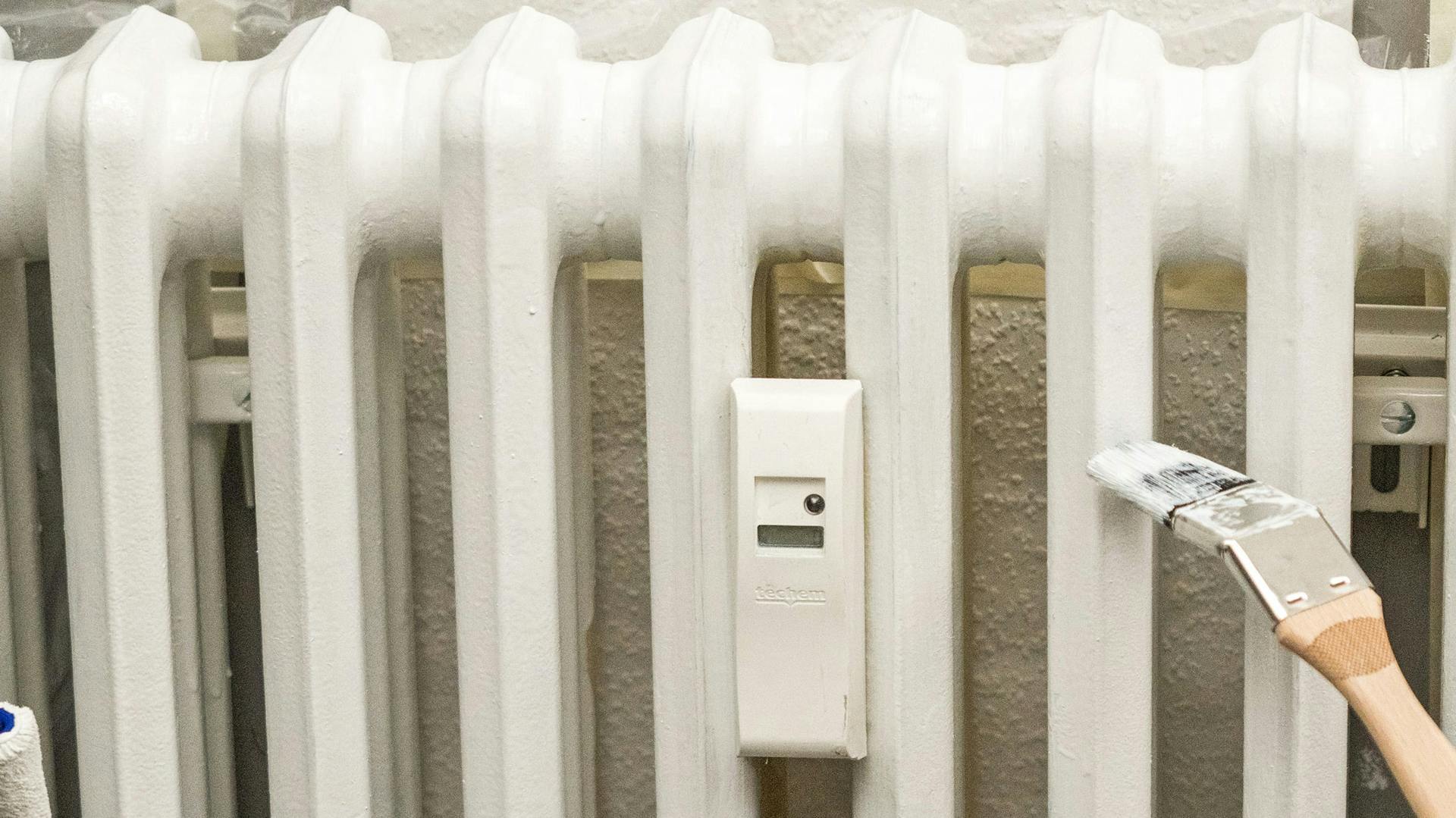 Heimwerker lackieren eine Heizung.