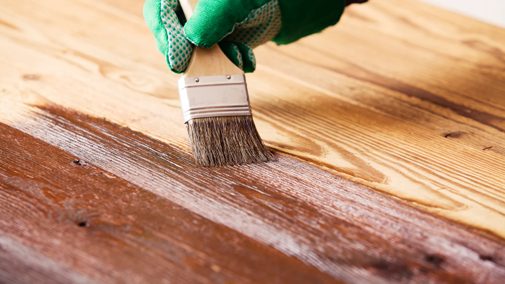 Holzbrett wird mit Beize bestrichen