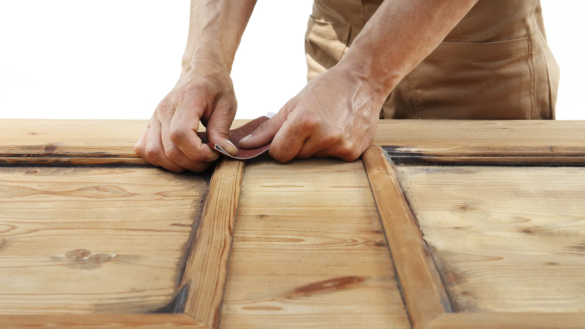 Person behandelt Holz mit Sandpapier