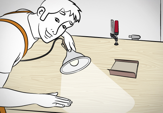 Pracovník kontroluje výsledok brúsenia pod lampou