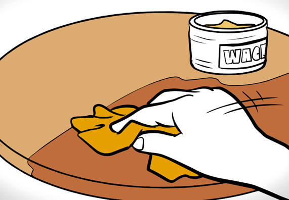 Hand mit Tuch und Holzwachs auf Tisch