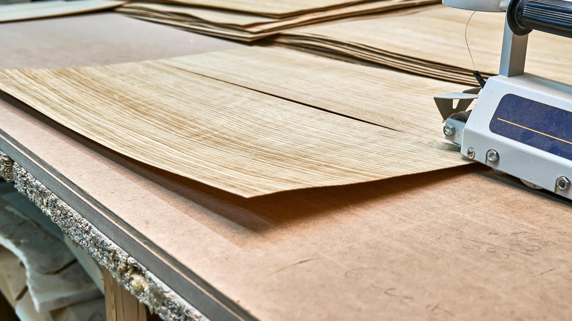 Eichenfurnier und elektrischer Hobel auf einer Werkbank.