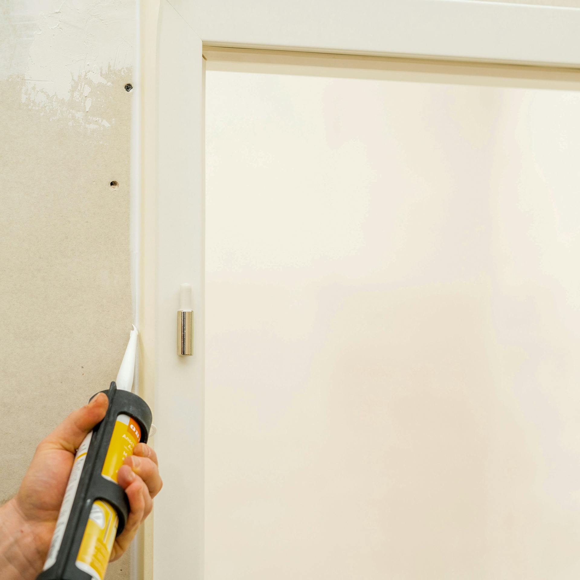 Handwerker spritzt Maleracyrl in die Fugen.