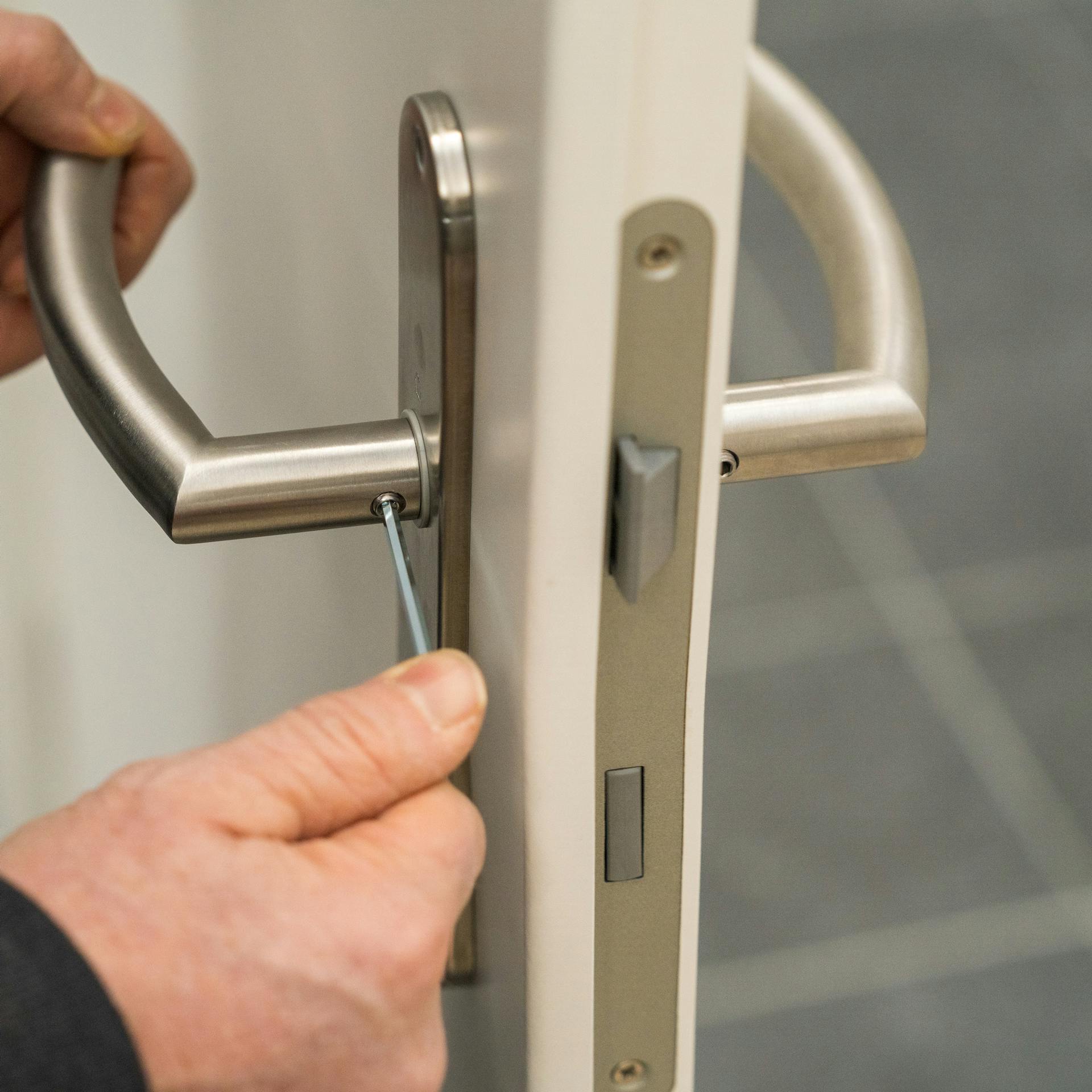 Handwerker setzt Beschläge ein.