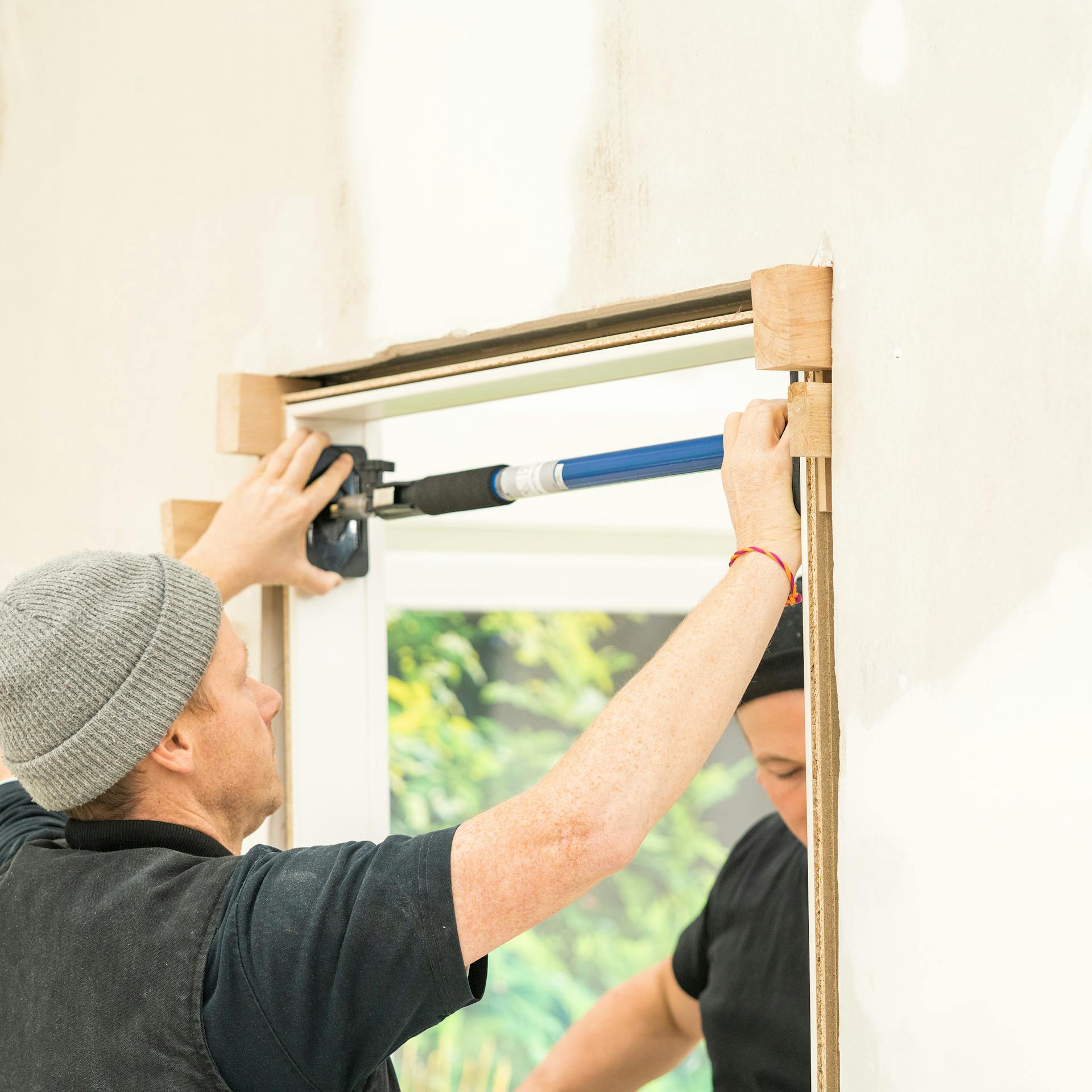 Handwerker fixiert die Zarge mit Richtkeilen.
