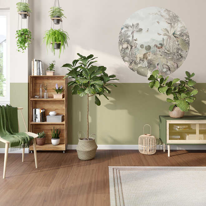 In einem Wohnzimmer mit vielen Pflanzen stehen ein Kistenregal und Sideboard Jona vor einer Wand,  die zweifarbig gestrichen worden ist und eine runde Tapete mit Dschungelmotiv  als Wandgestaltung nutzt.