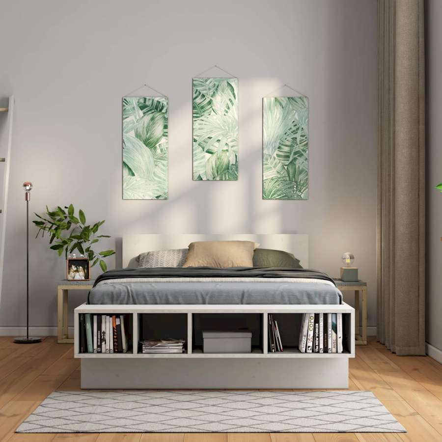 Über einem Bett hängen florale Tapeten.