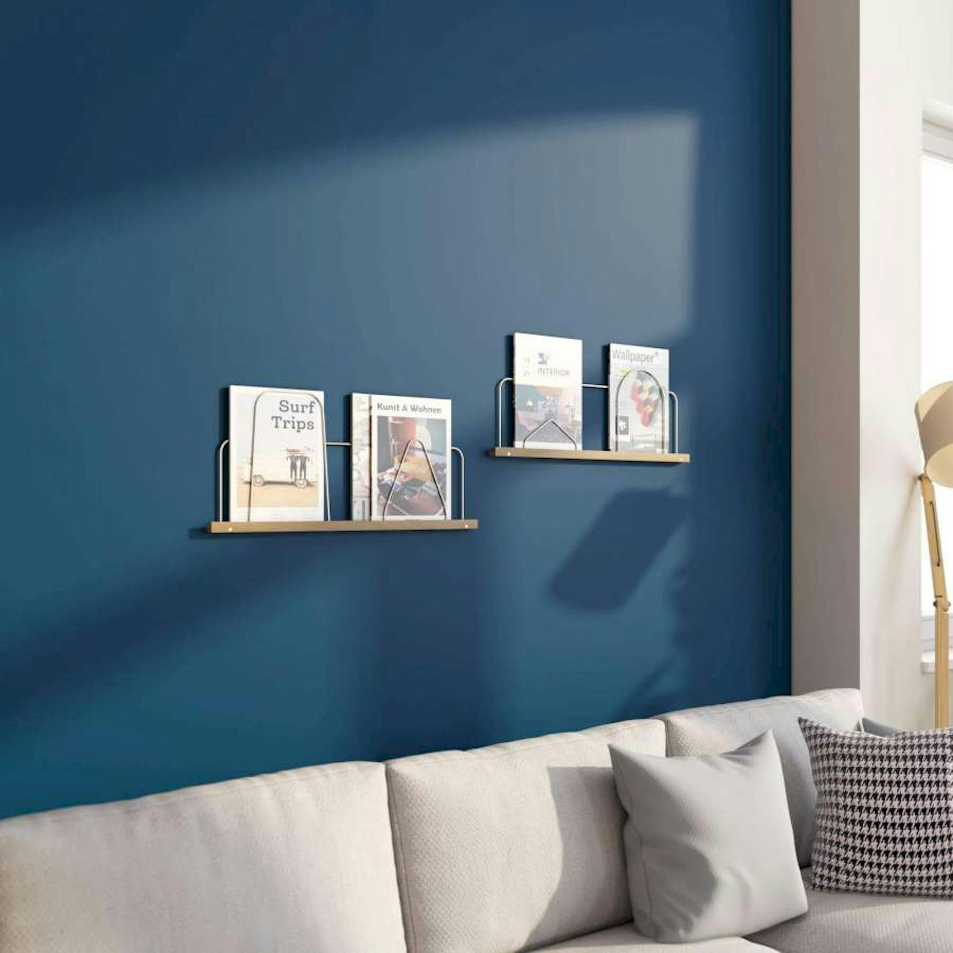 DIY-Magazinhalter aus Messingrohr an einer dunkel-blauen Wand montiert