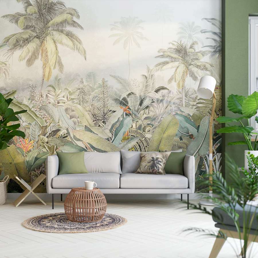 Ein helles Sofa, wo neben ihm ein Magazinhalter platziert ist, steht zentriert vor einer Wand mit großer Dschungelmotiv-Tapete.