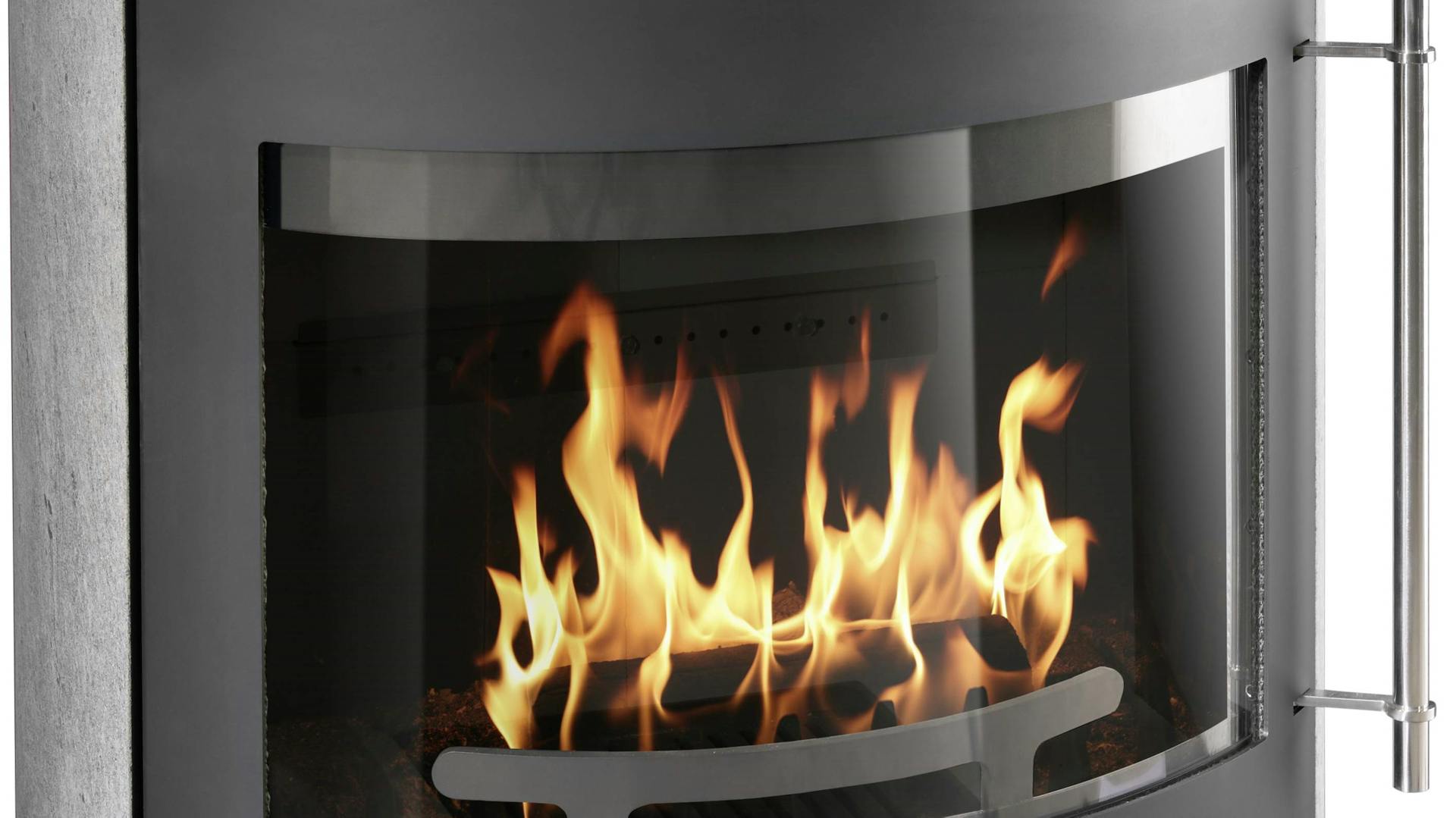 Primo piano del vetro pulito di una stufa caminetto. All’interno, il fuoco è acceso.