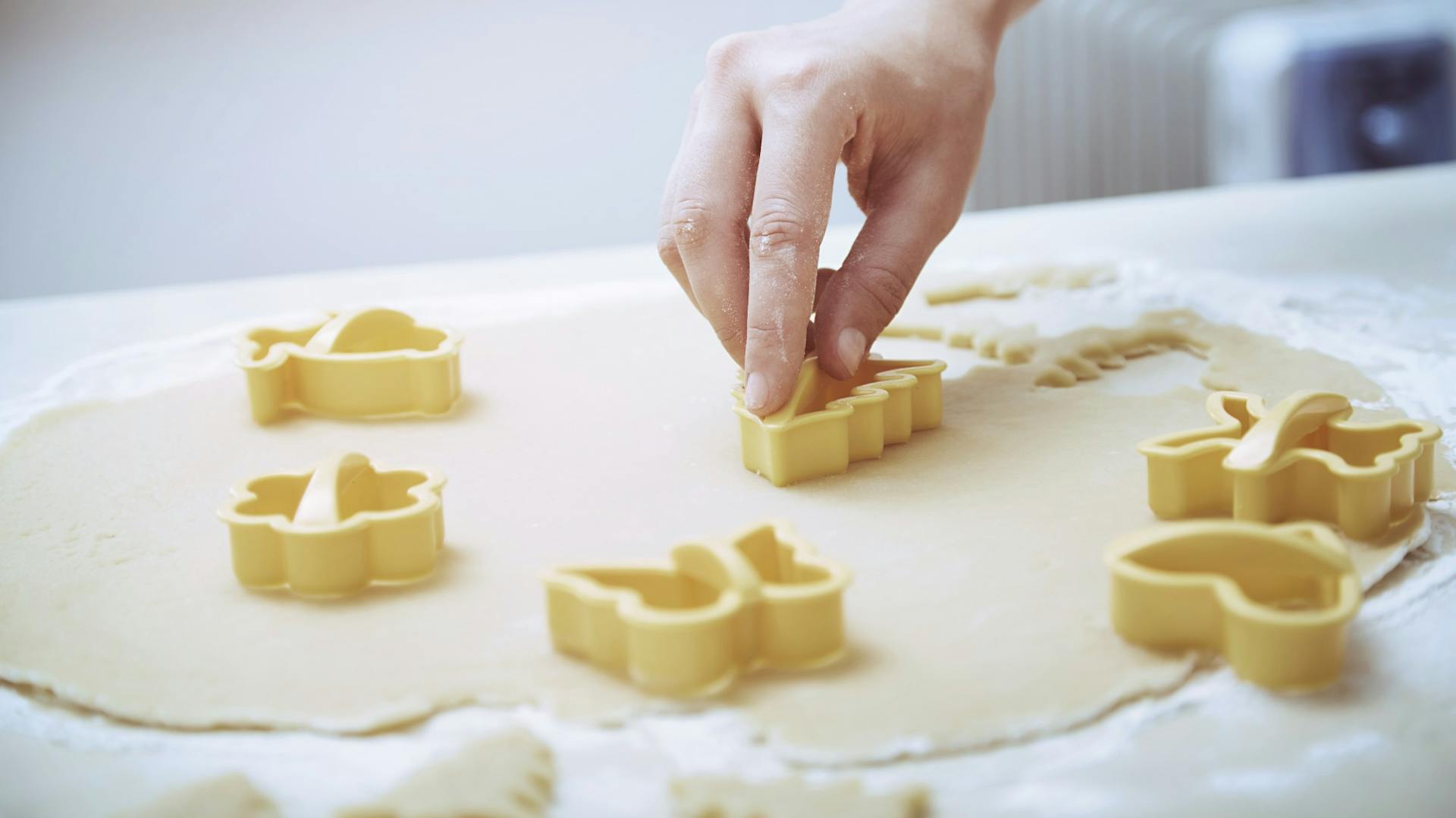 Ručně vykrajujeme sušenky z těsta pomocí vykrajovátek.