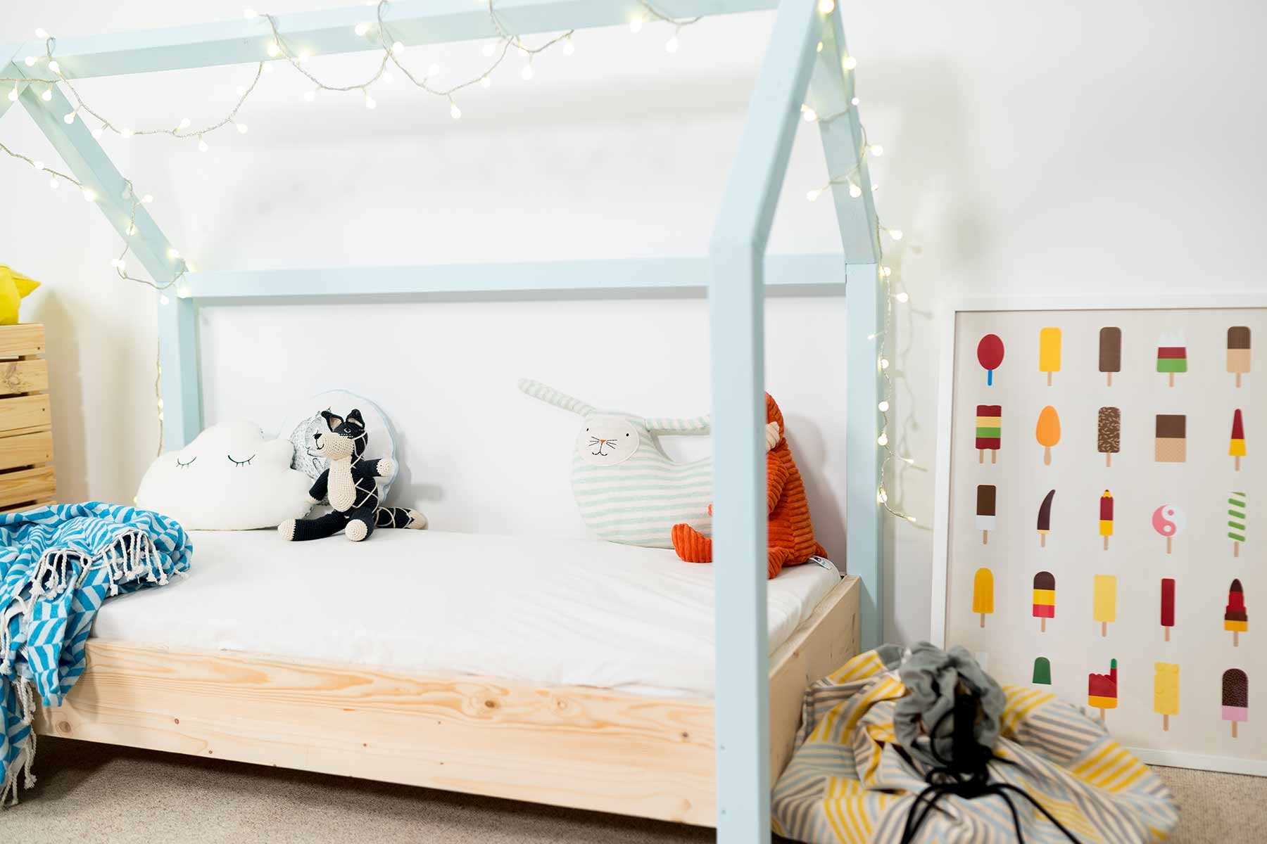 Seitliche Ansicht auf das Kinderbett Moritz mit hellblauen Balken.