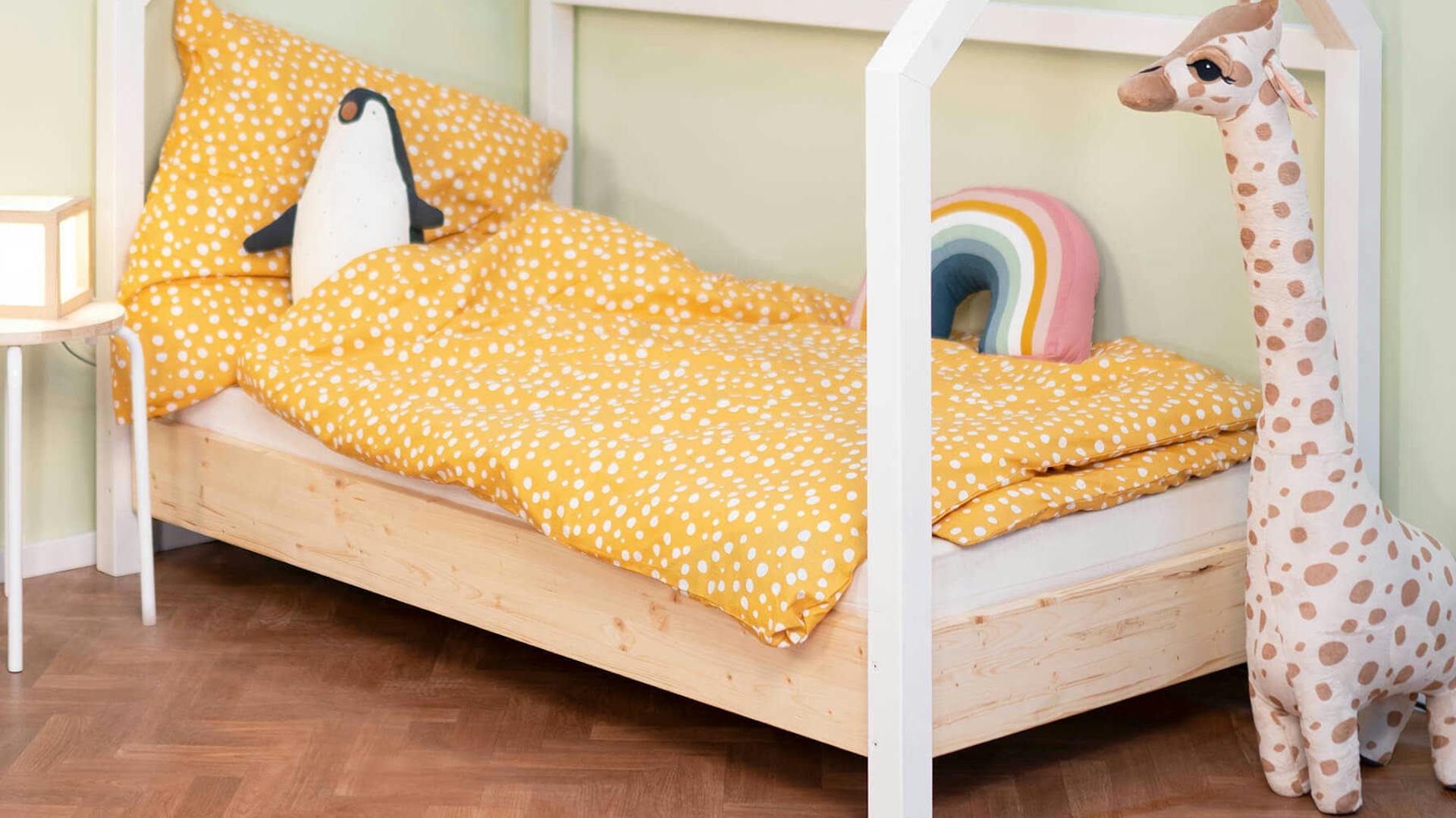 Seitliche Ansicht auf Kinderbett Moritz in gelblichen Farben.