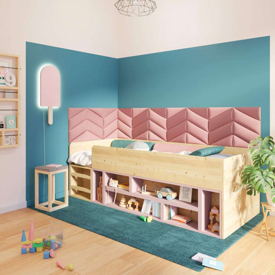 In einem Kinderschlafzimmer steht ein Bett in einer blau gestrichenen Ecke auf einem Teppich. Über dem Bett hängen rosane Wandkissen.