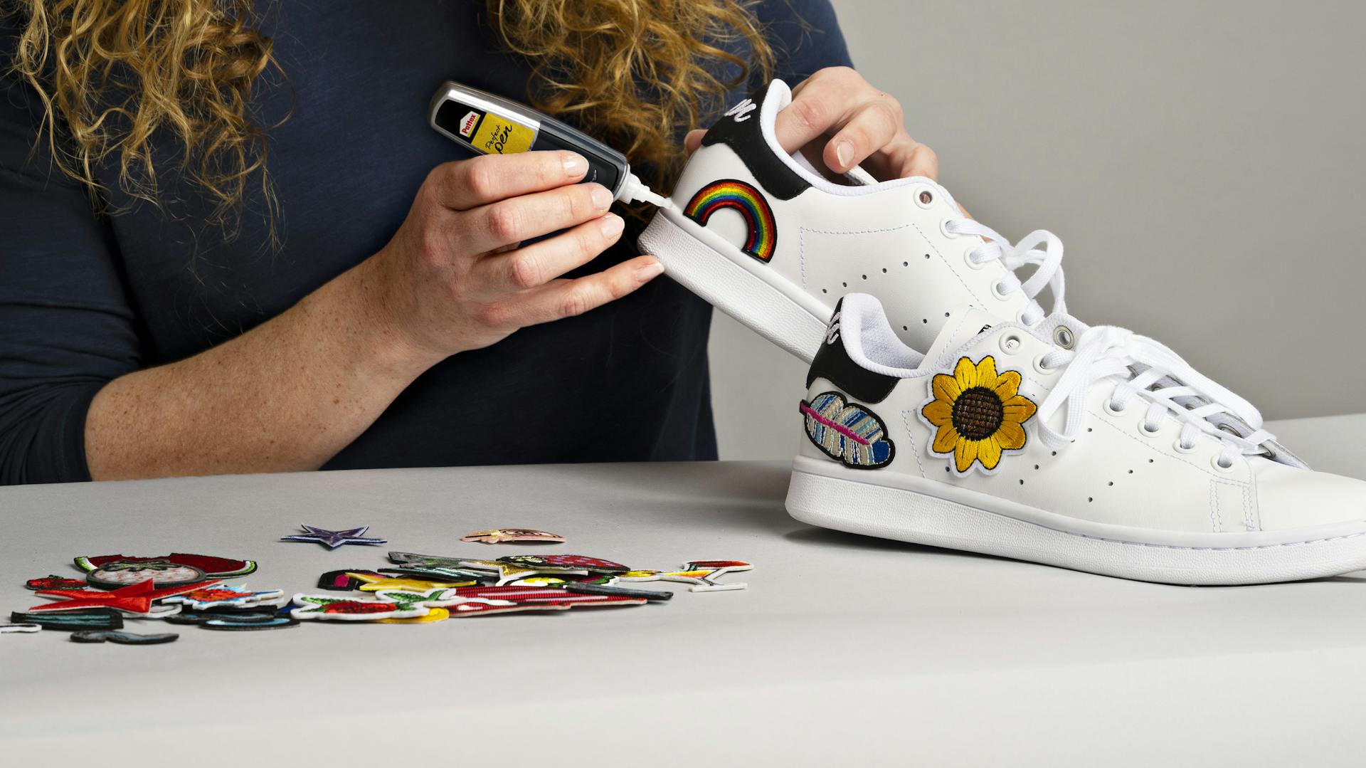 Frau klebt Dekoelemente auf Schuh