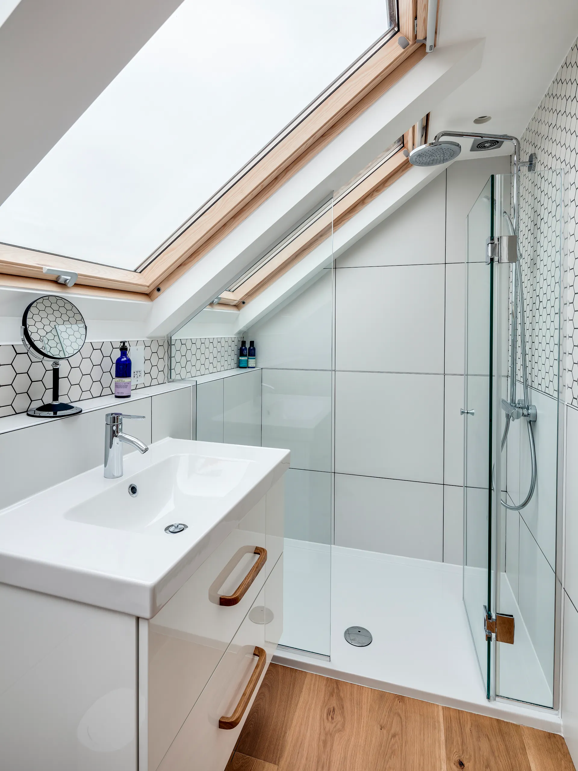 Kleines Badezimmer mit Dusche, Waschbecken, Fenster und Dachschräge