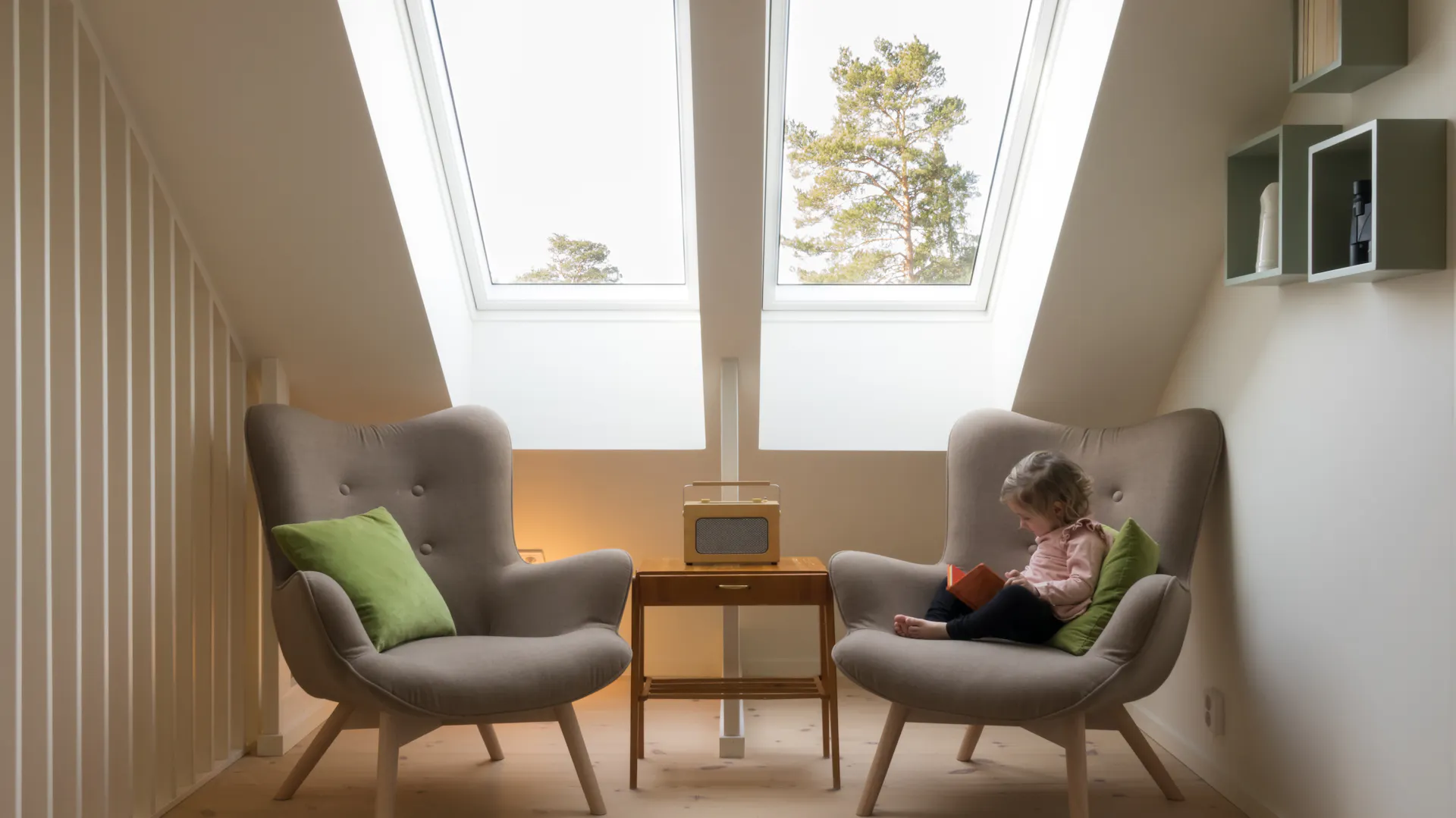 Zwei Sessel in kleinem Raum mit Dachschräge und Dachfenster.