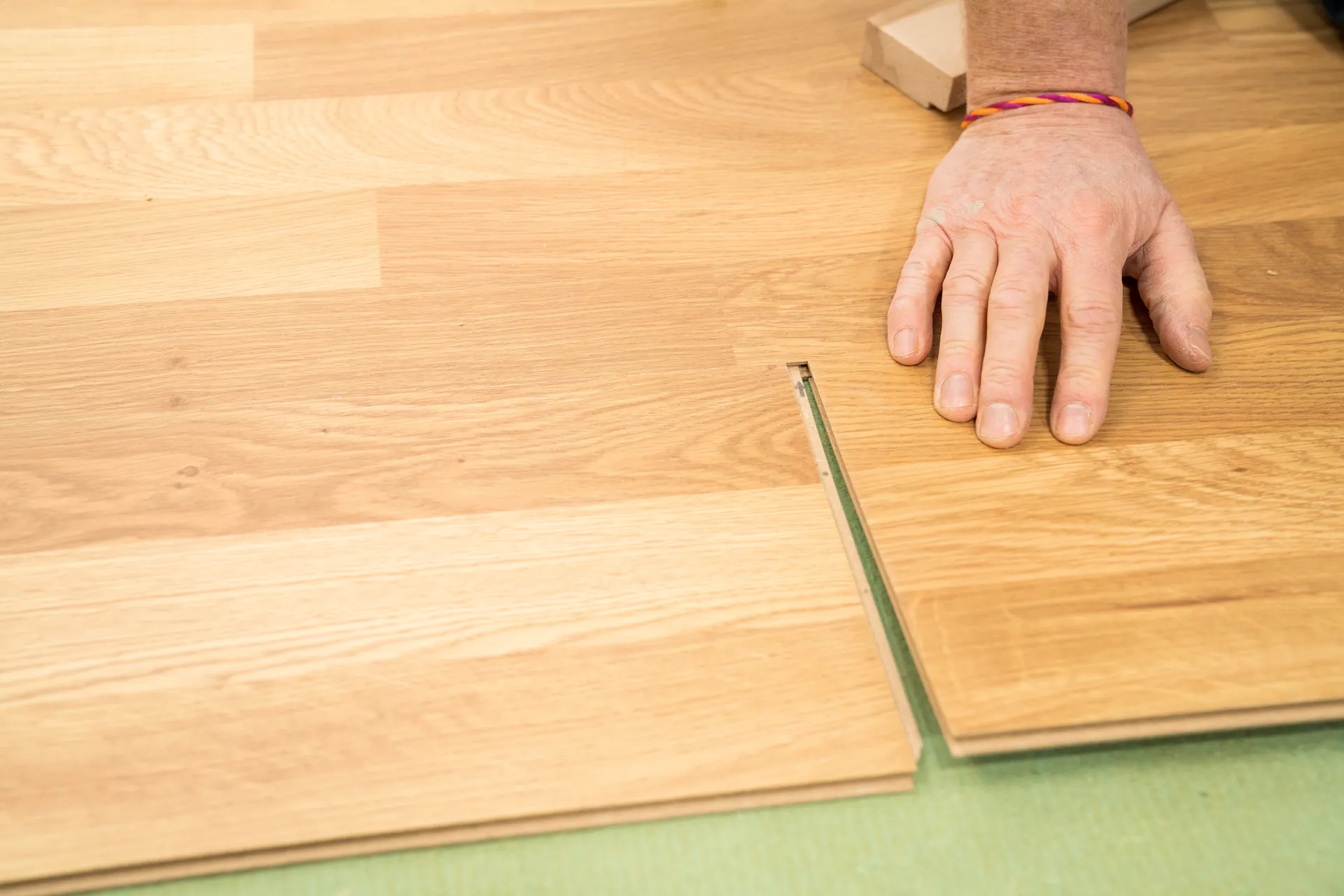 L’appassionato del fai-da-te fissa le file di laminato a clic.