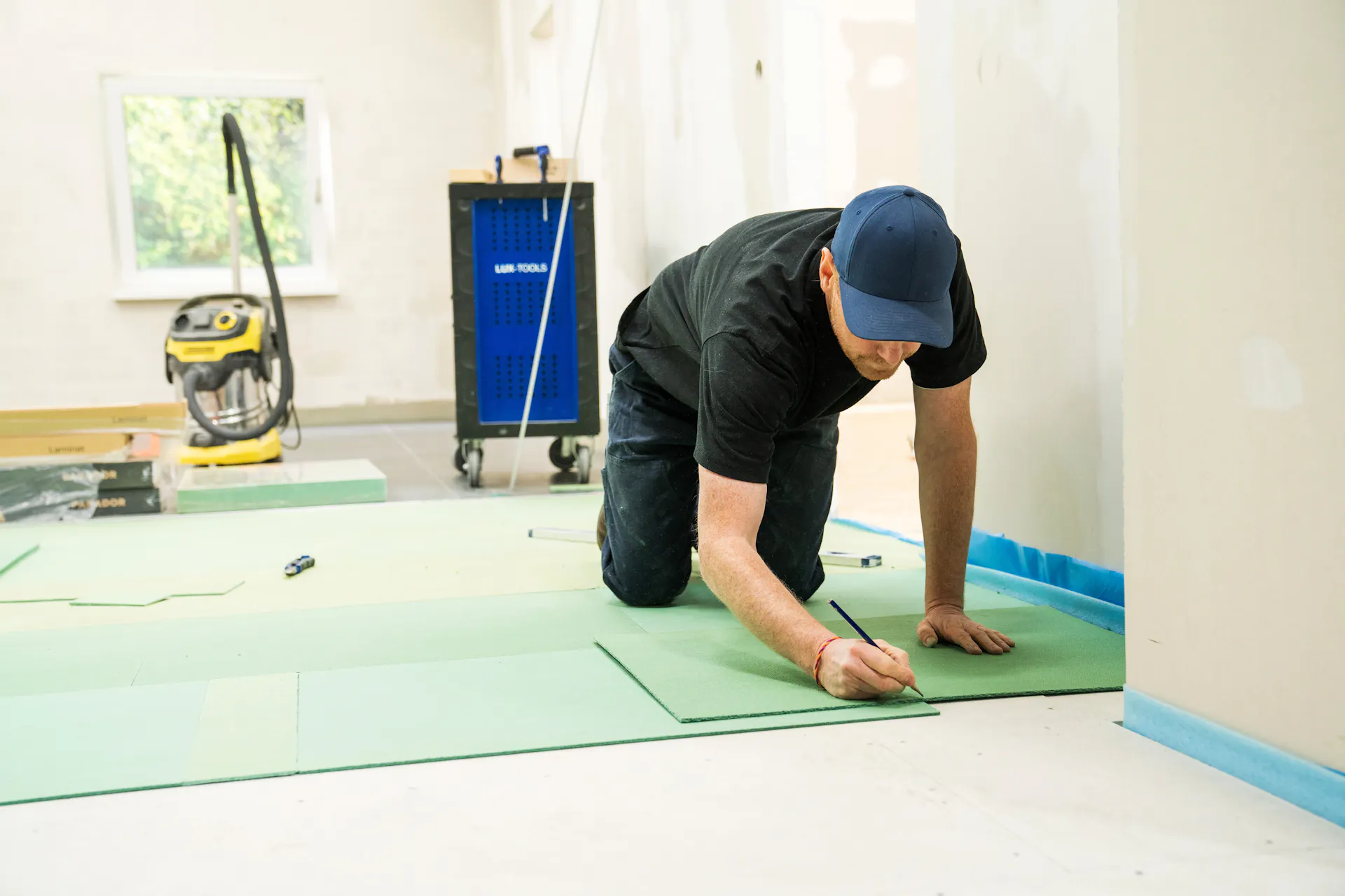 L’appassionato del fai-da-te applica l’isolamento acustico sul pavimento.