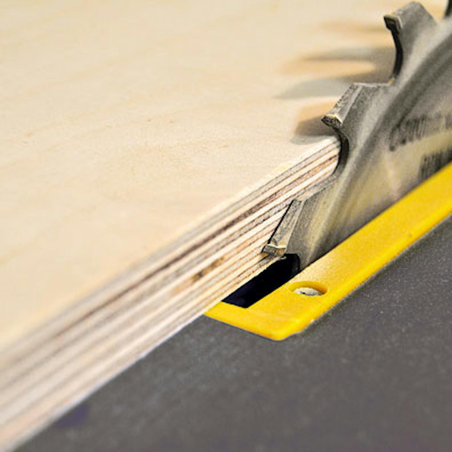 Eine Holzplatte wird mit einer Kreissäge zugesägt.