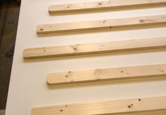 Verschraubte Abstandshalter auf der Holzplatte.