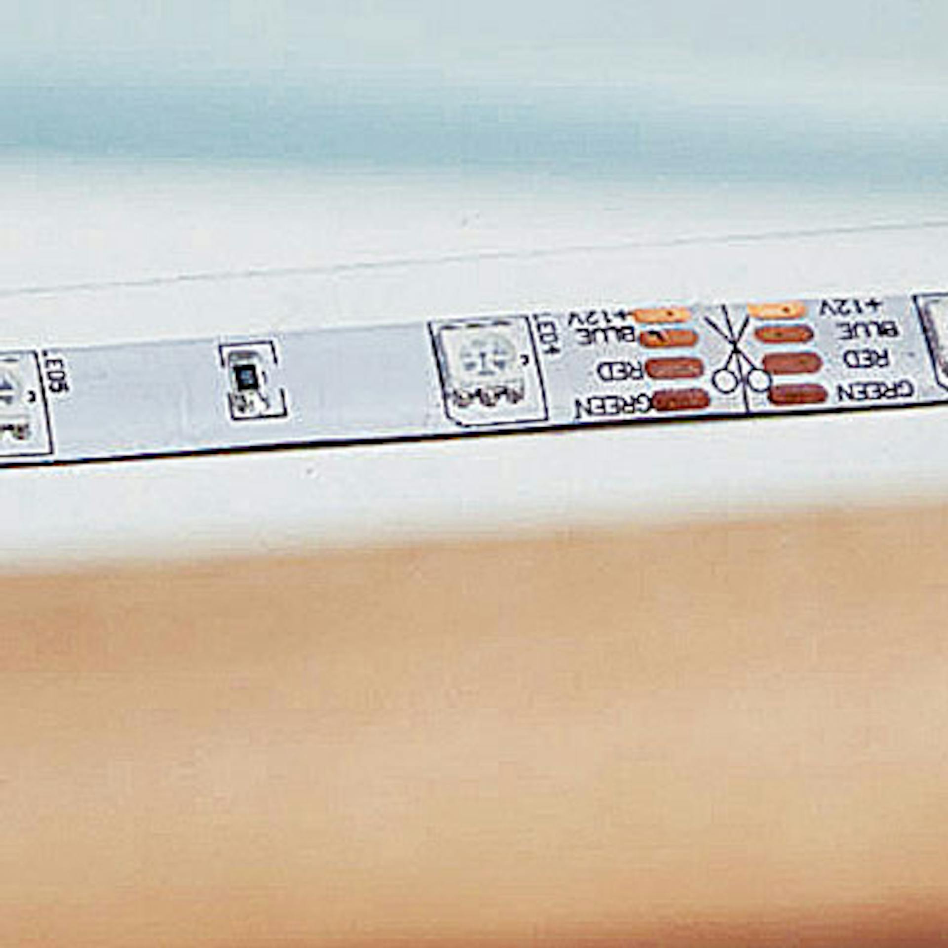 Ein LED-Streifen wird auf eine Leiste geklebt.