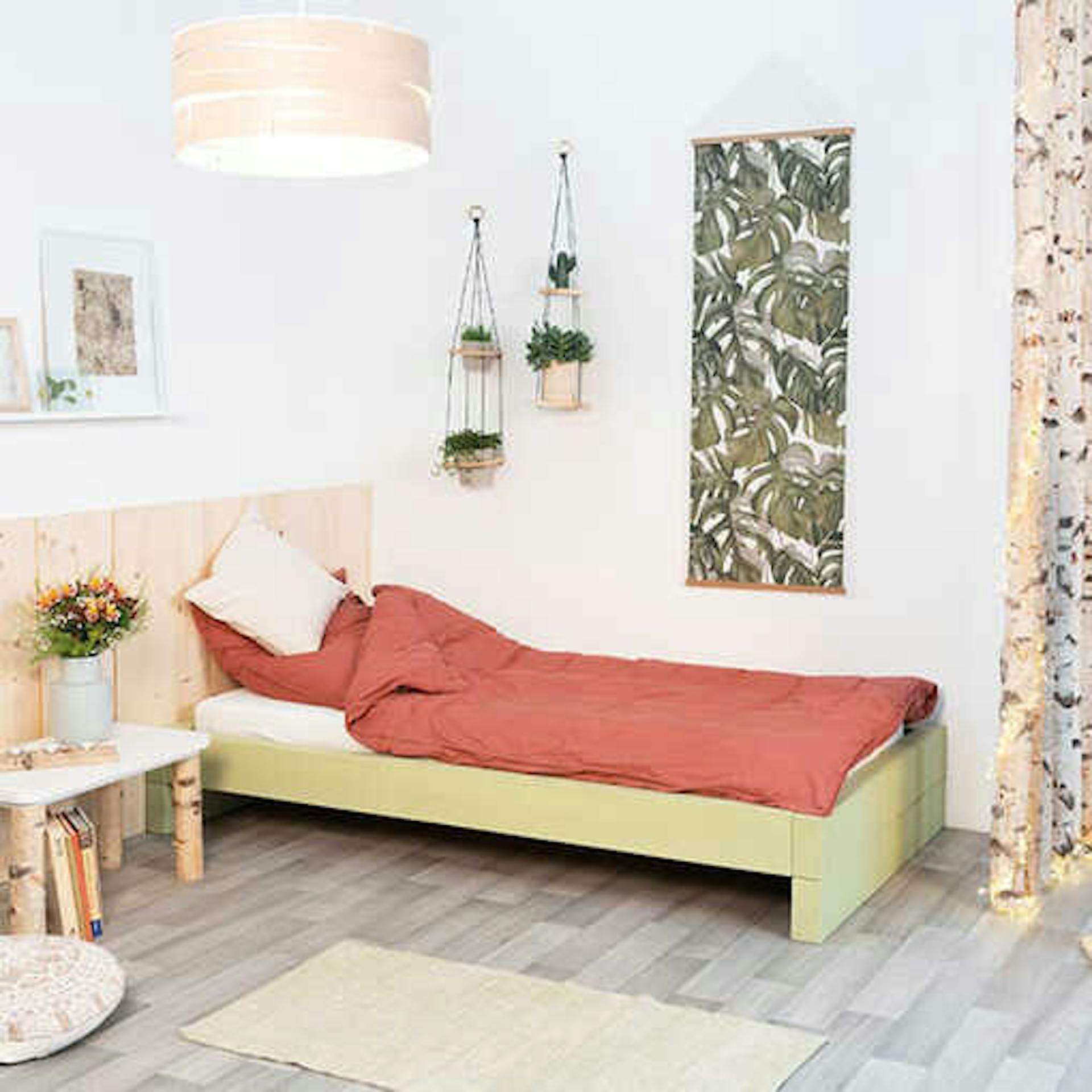 Ein Schlafzimmer mit einem natürlichen Look durch den Einsatz von Birkenholz beim Bett, Nachtisch und der Deko