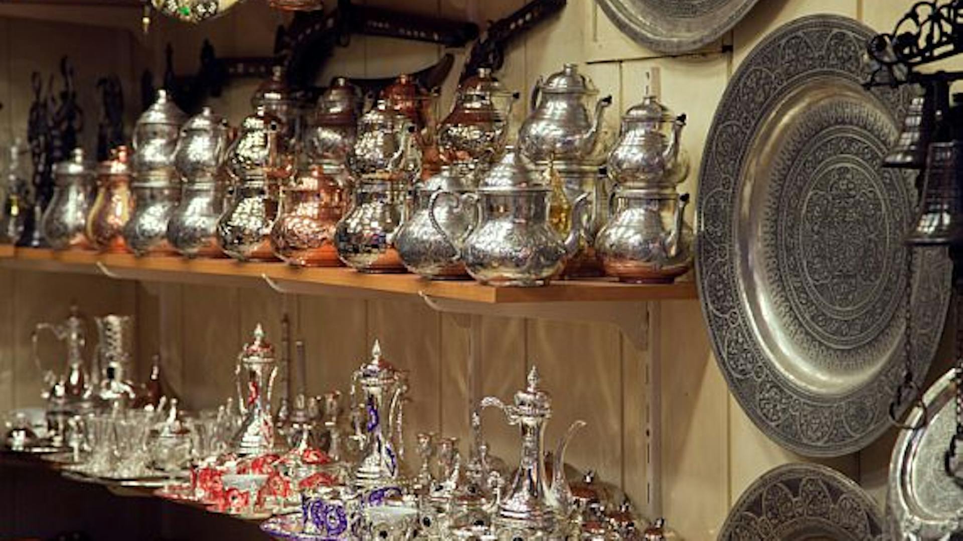 Cínové nádoby na poličkách a cínové taniere na stene