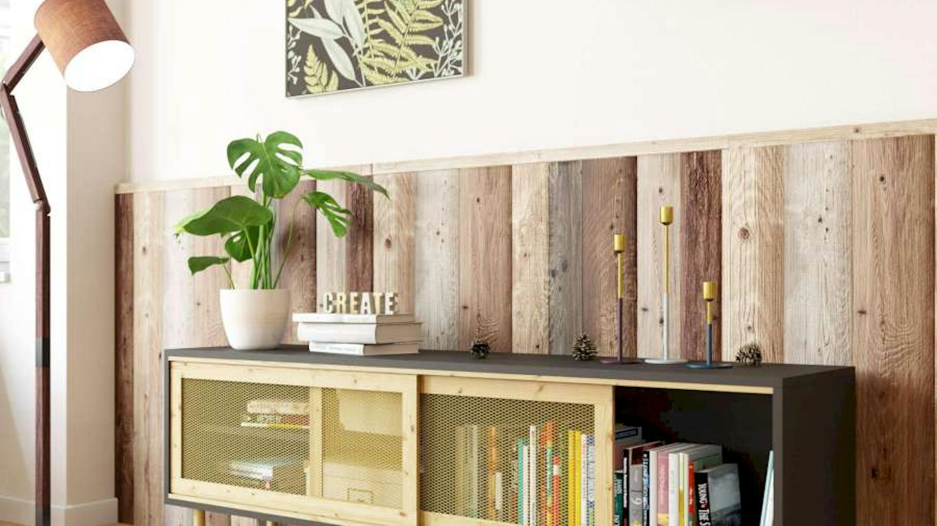 Ein schwarzes Sideboard steht vor einer Wand, die mit rustikalem Altholz verkleidet ist.