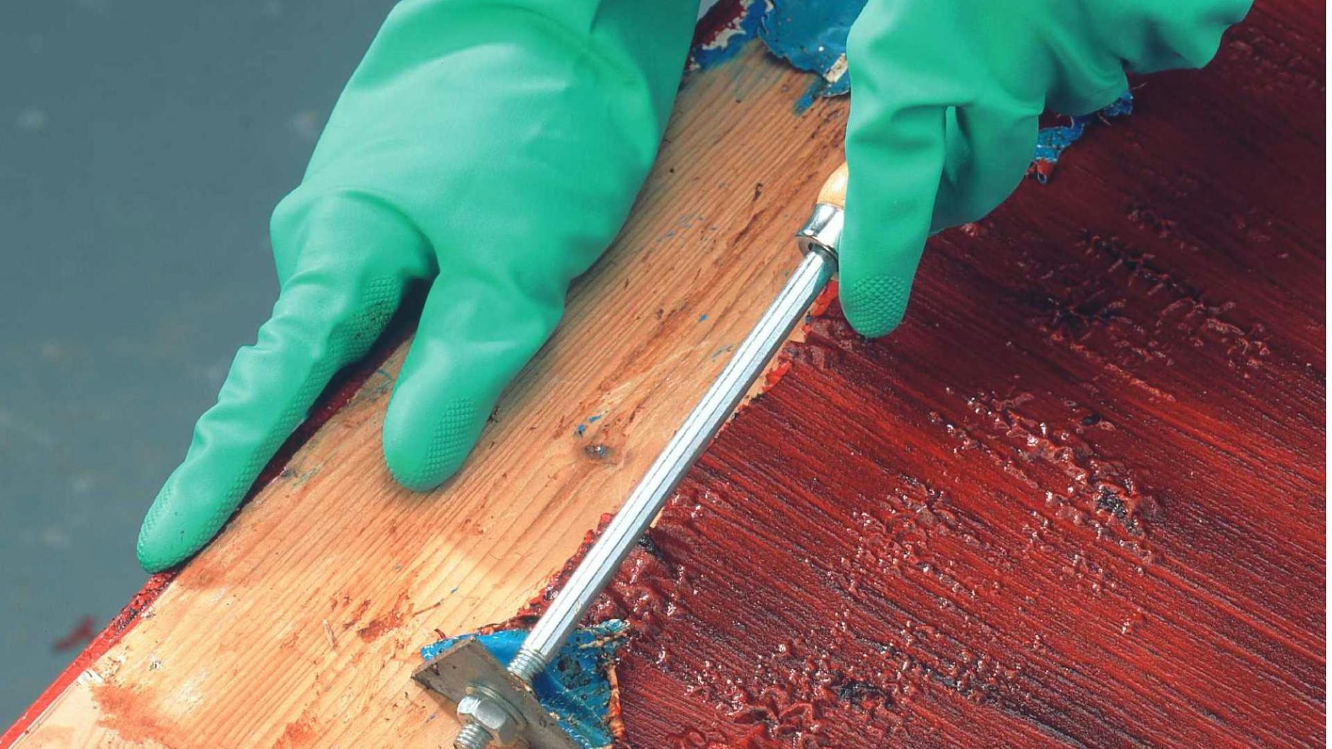 Festék eltávolítása egy bútorról festékmaróval.