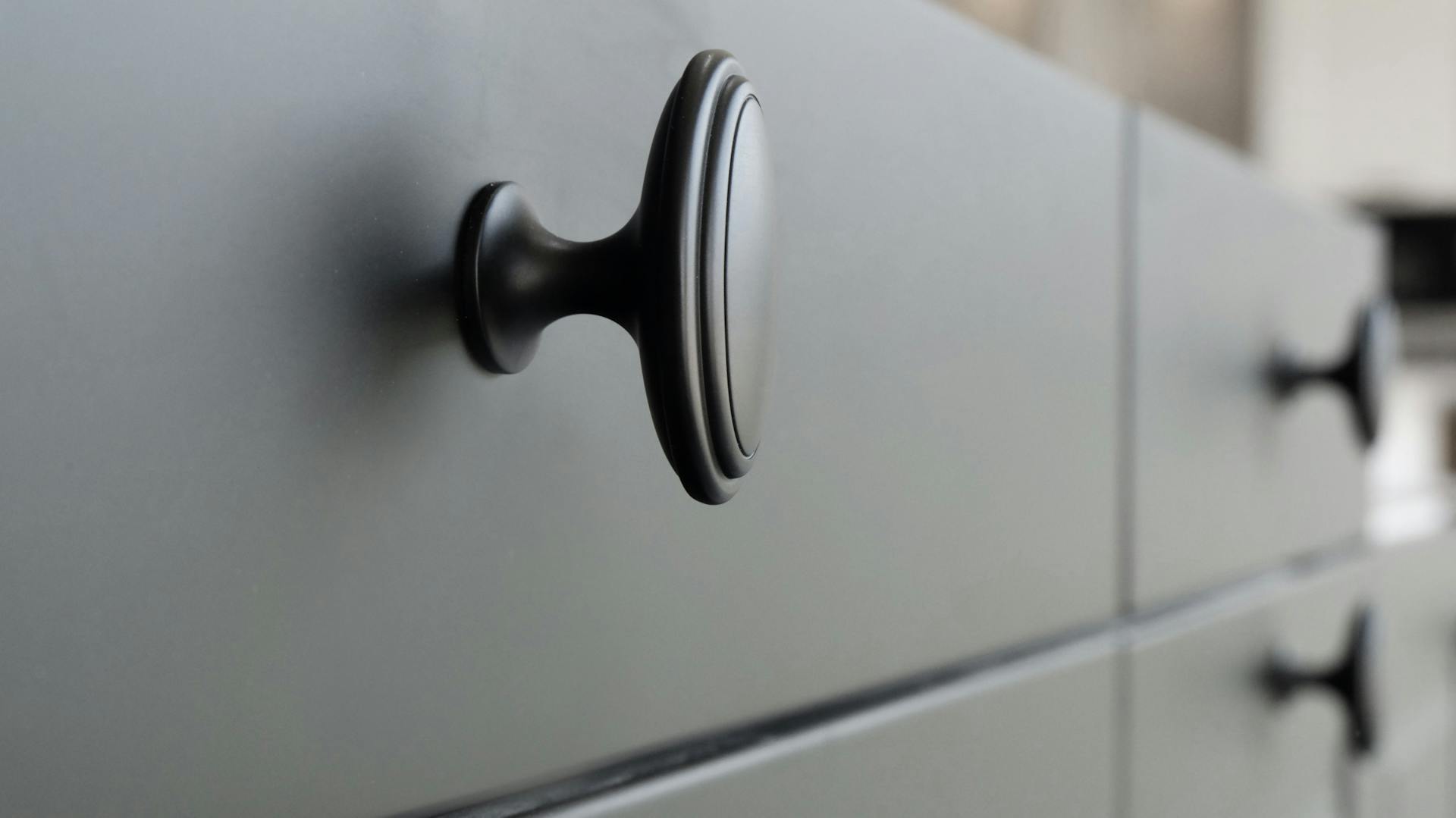 Dunkle Kommode mit schlichten, anthrazitfarbenen Griffen