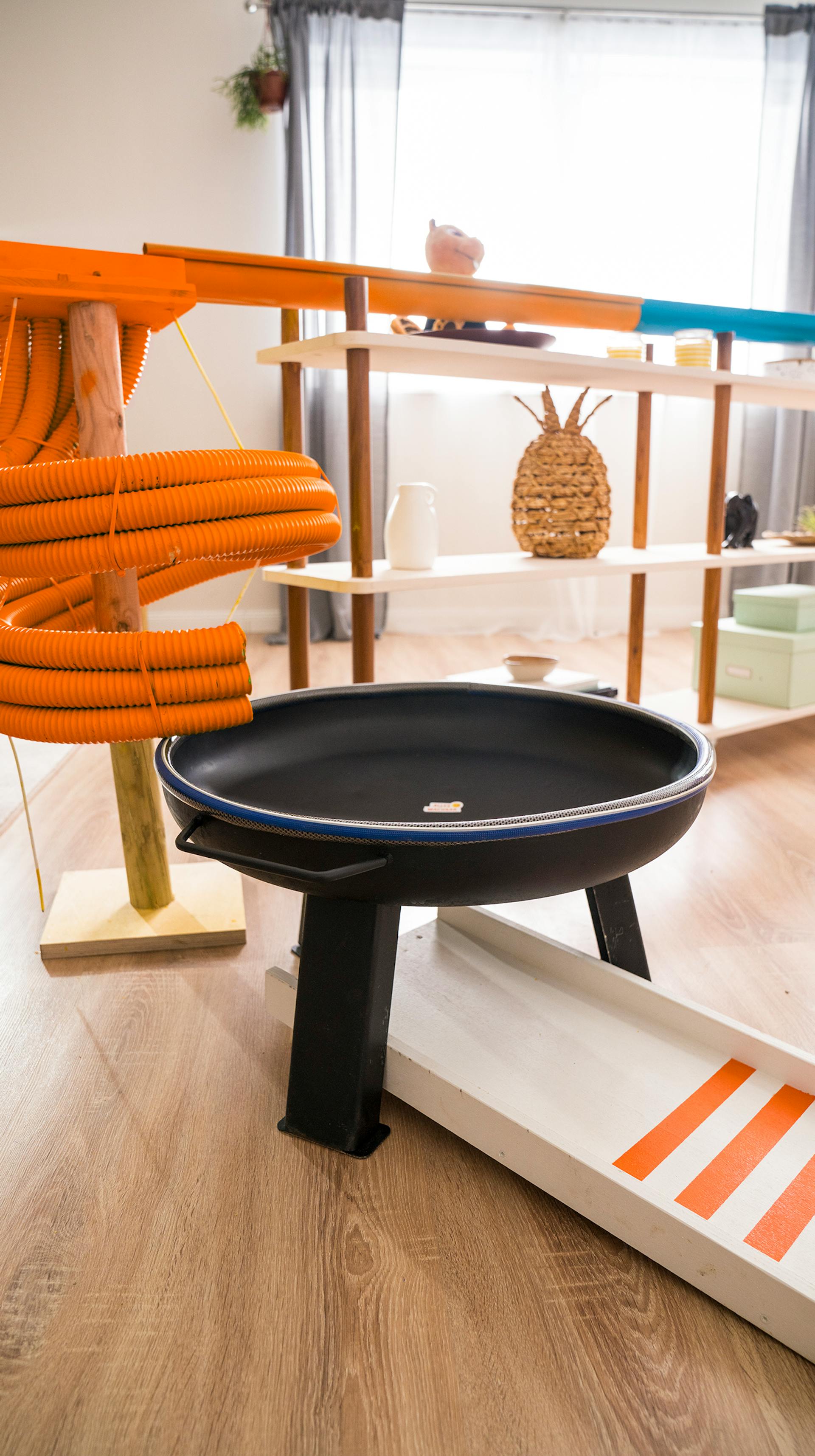 Das ende der Murmelbahn ist eine kleine Rampe mit orangenen Streifen, unterhalb der Feuerschale.