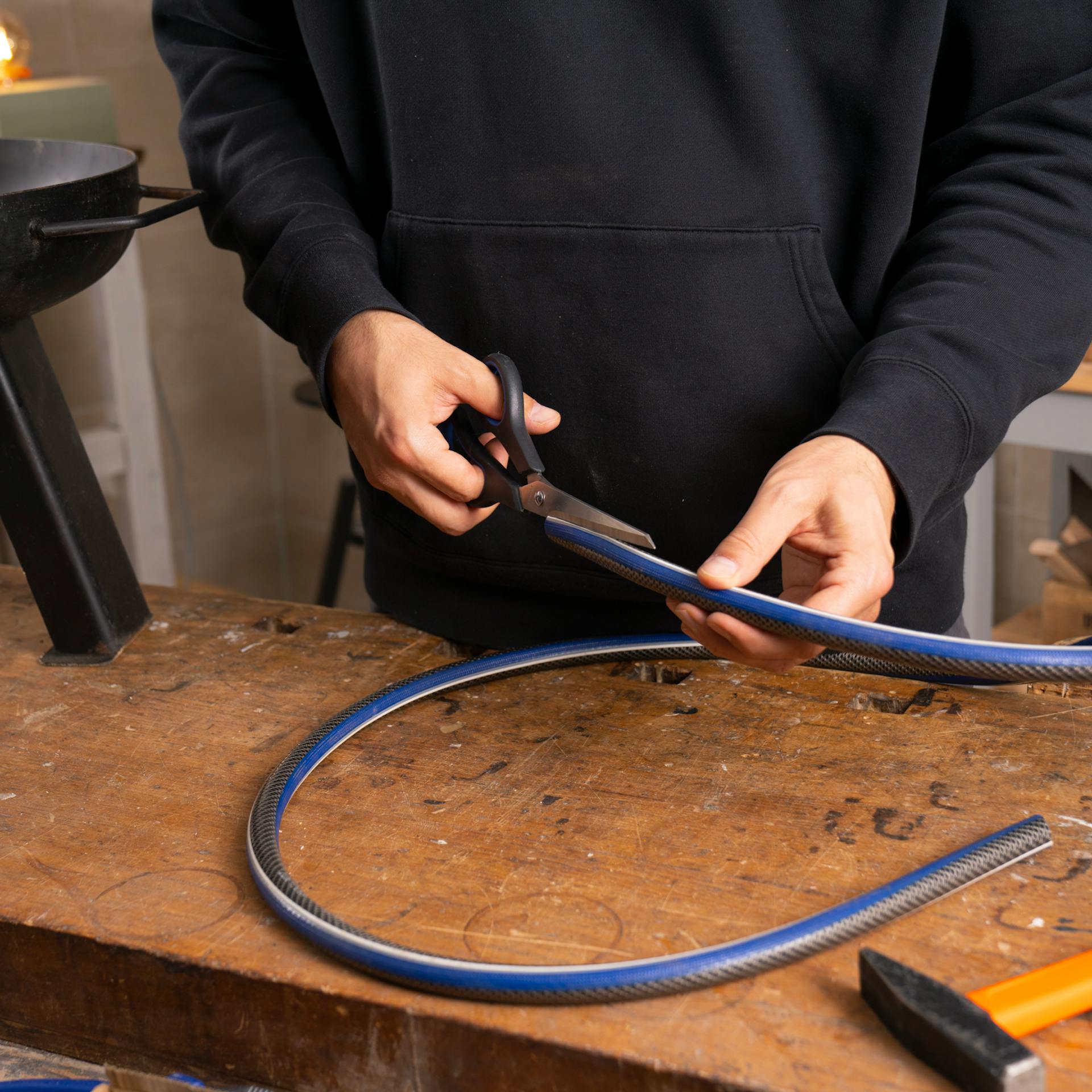 Tmavá rúrka sa prestrihne nožnicami.